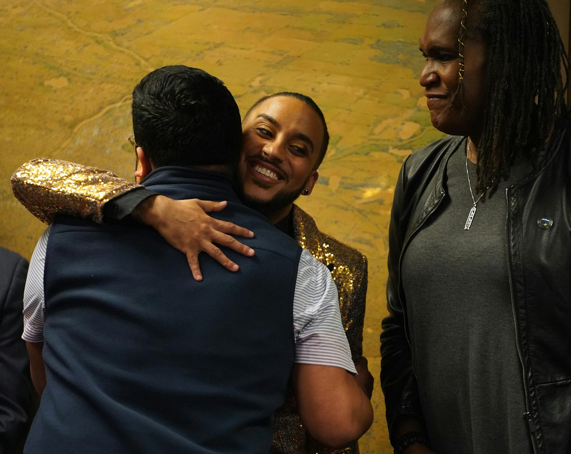 Council Member Phillipe Cunningham hugged Roger Sanchez, a survivor of conversion therapy as Council Member Andrea Jenkins stood by.