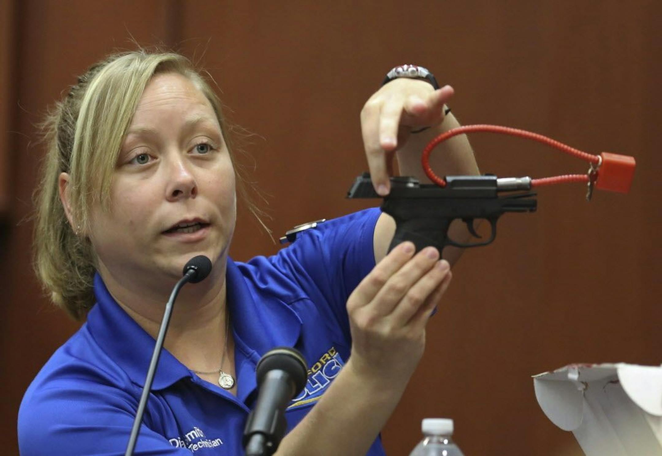 Diana Smith, crime scene technician for the Sanford Police Department, shows George Zimmerman's gun, which was collected as evidence, to the jury during Zimmerman's trial in Seminole circuit court in Sanford, Florida, Tuesday, June 25, 2013.