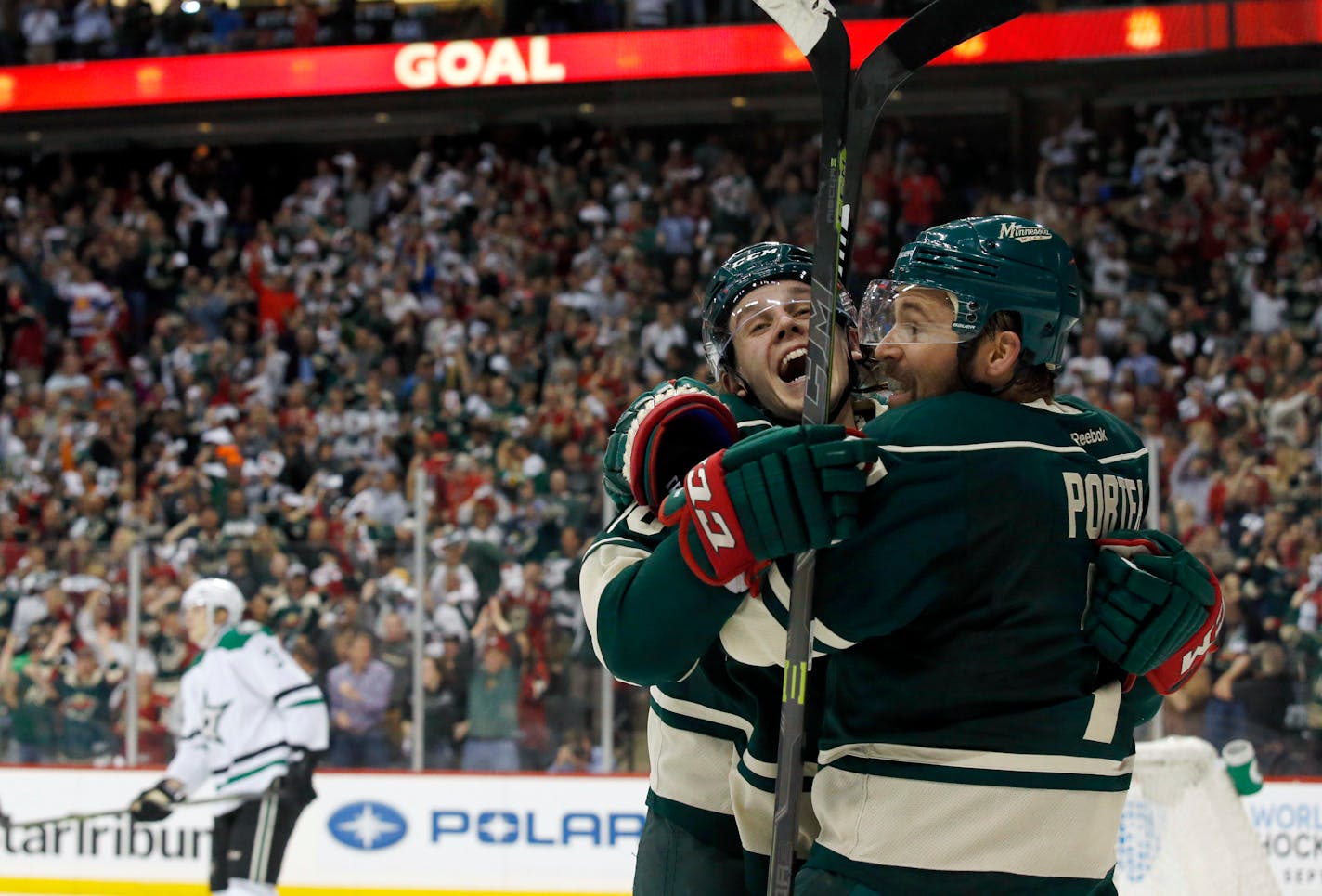 Minnesota Wild left wing Chris Porter, right, and left wing Erik Haula celebrate Porter's goal on Dallas Stars goalie Kari Lehtonen during the first period of Game 3 in the first round of the NHL Stanley Cup playoffs in St. Paul, Minn., Monday, April 18, 2016. The Wild won 5-3. (AP Photo/Ann Heisenfelt)