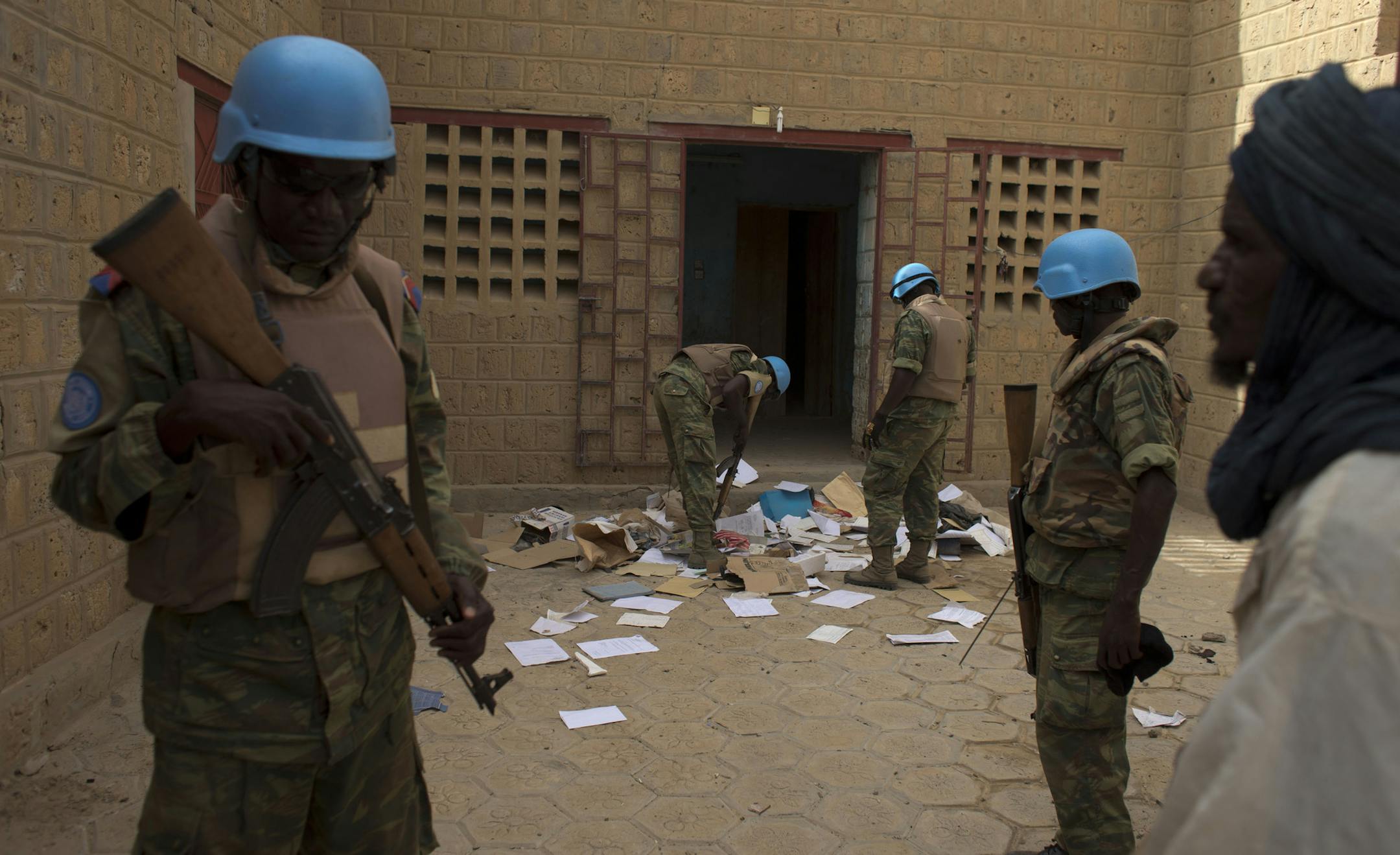 FILE - In this July 23, 2013 file photo, United Nations peacekeepers search a house suspected to have been used by members of al-Qaidaís North African branch in Timbuktu, Mali. The al-Qaida cell occupied Timbuktu for 10 months until January 2013. When they fled, they left behind thousands of pages of documents, including over 100 receipts, showing that they assiduously tracked their cash flow, down to the $0.60 one of them spent for a single light bulb. The accounting system on display sugg
