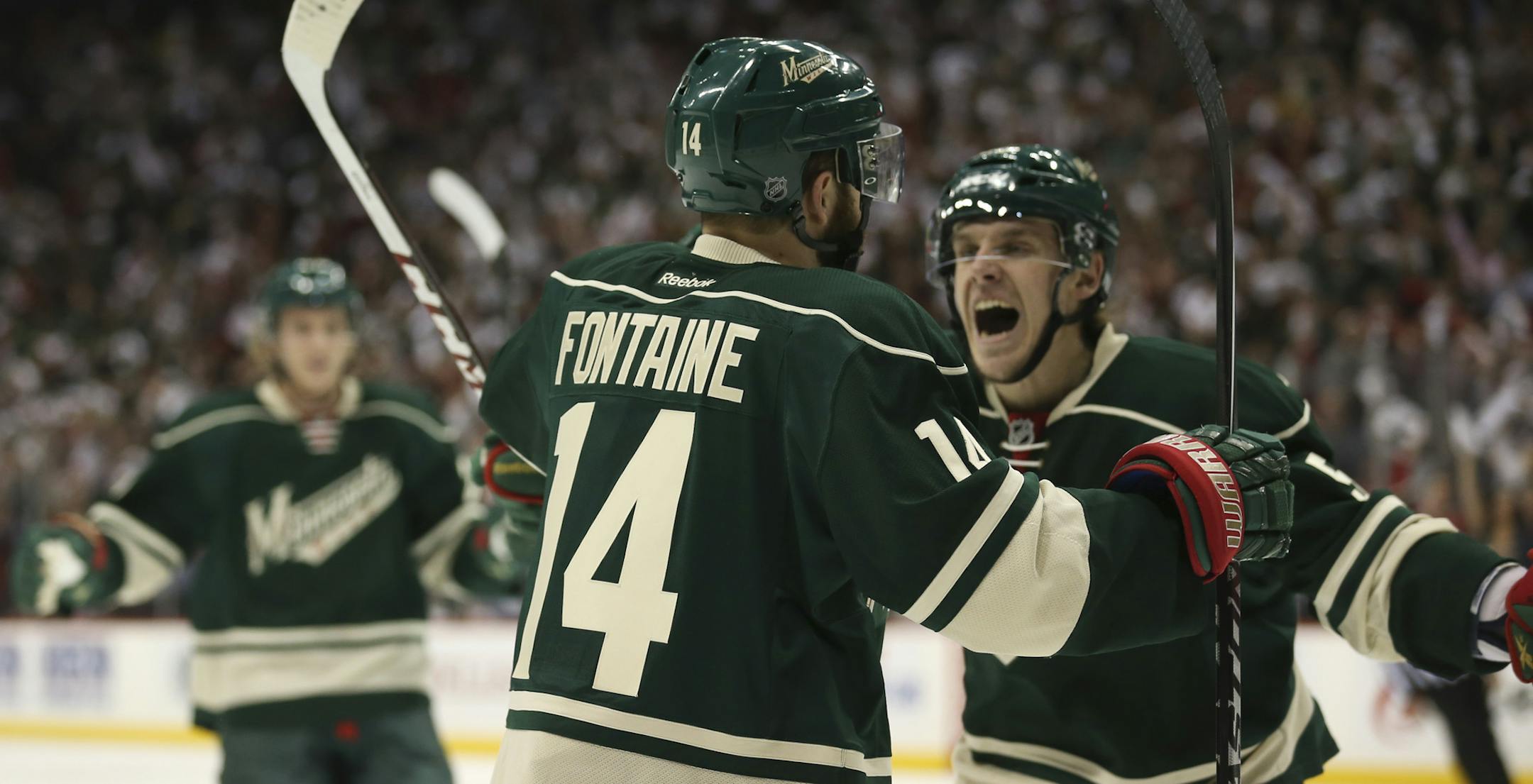 Minnesota Wild right wing Justin Fontaine (14) was about to be congratulated by teammate Erik Haula (56) after his first period goal Friday night at Xcel Energy Center in St. Paul.