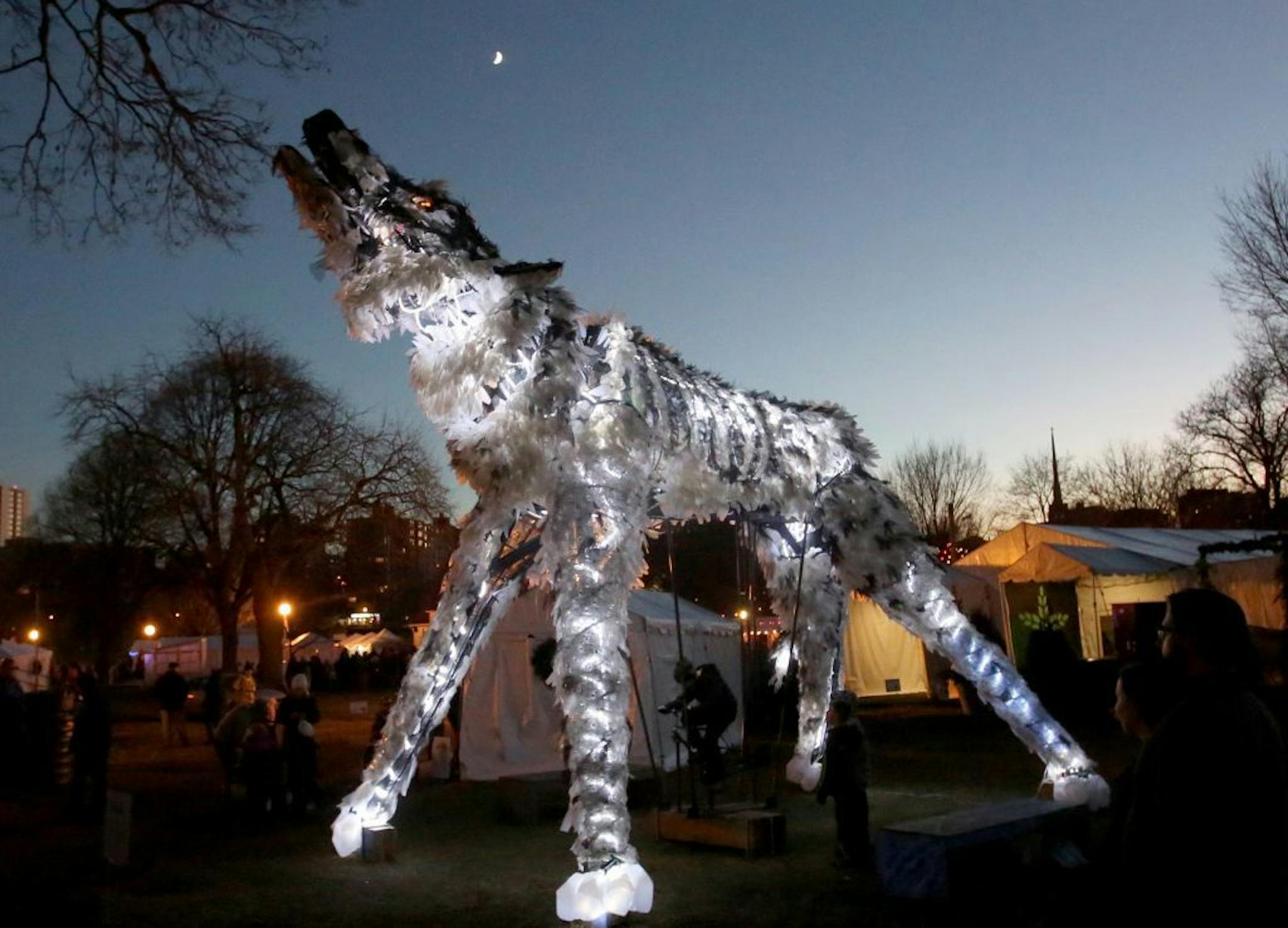 The Wolf and Moose, a Christopher Lutter-Gardella creation, are interactive exhibits that light up and allow viewers to peddle and engage in the art itself. The animals are comprised of 90 percent recycled waste-stream materials. Total products for each sculpture include 7,179 recycled plastic materials (bottles, jugs), 320 yards of recycled window screen and more. Here, wolf lights up the darkness during Holidazzle Friday, Nov. 24, 2017, at Loring Park in Minneapolis MN.