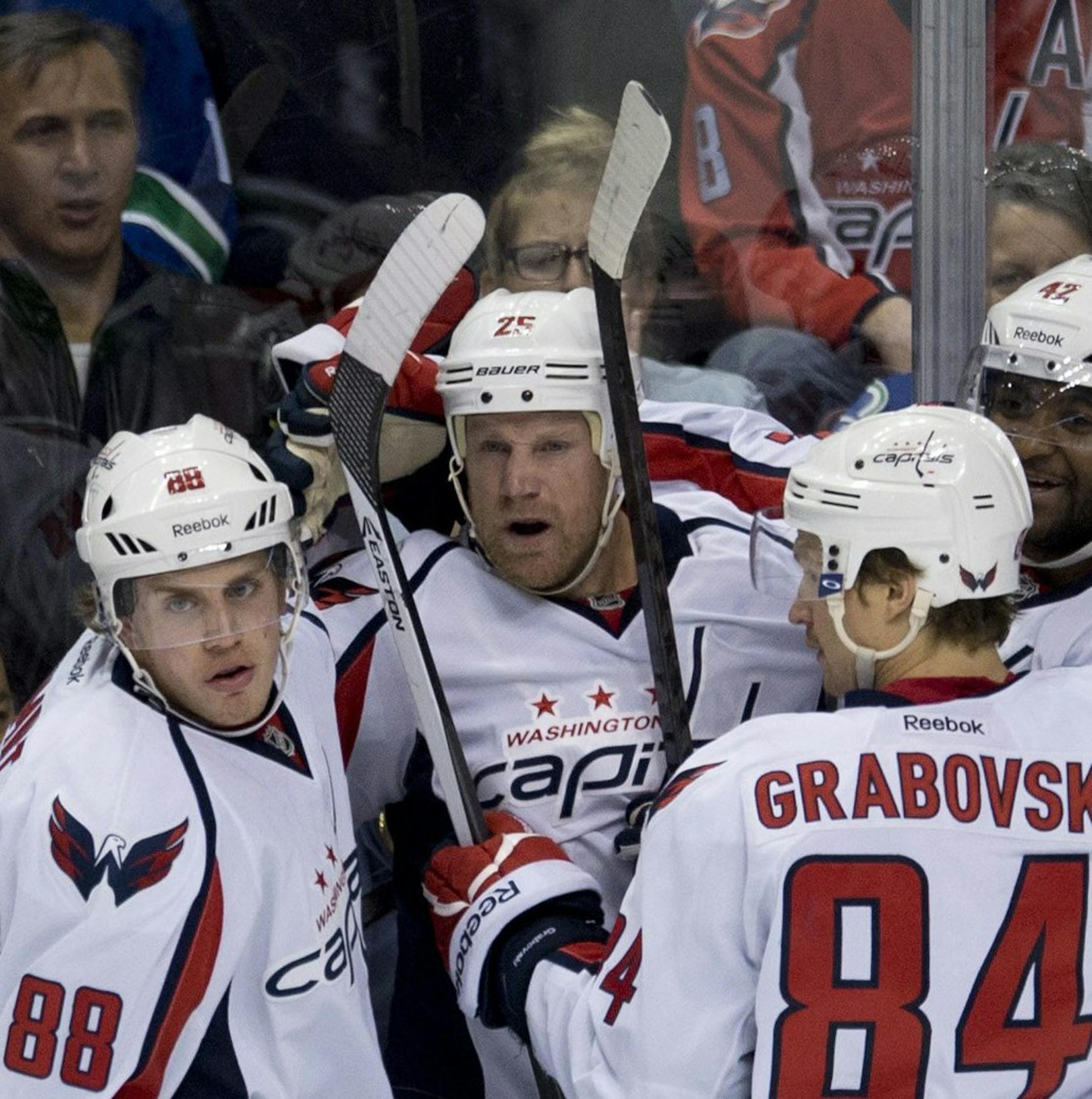 Washington Capitals left wing Jason Chimera (25) celebrates his goal with teammates Nate Schmidt (88), Mikhail Grabovski (84) and Joel Ward (42 )during the first period of NHL hockey action against the Vancouver Canucks in Vancouver, British Columbia on Monday, Oct. 28, 2013. (AP Photo/The Canadian Press, Jonathan Hayward) ORG XMIT: MIN2013110621551992