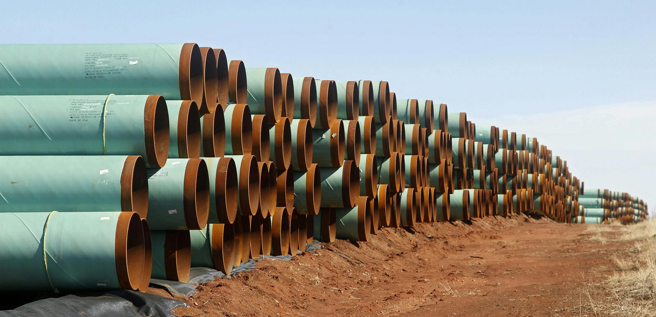 FILE - In this Feb. 1, 2012 file photo, miles of pipe for the stalled Canada-to-Texas Keystone XL pipeline are stacked in a field near Ripley, Okla. An Associated Press review of every cross-border pipeline application since 2004 shows that the Keystone review has been anything but ordinary. The company hoping to build Keystone has been waiting for a decision for nearly 7 years &#xf3; or more than five times the average. (AP Photo/Sue Ogrocki, File) ORG XMIT: MIN2015100514424030 ORG XMIT: MIN151