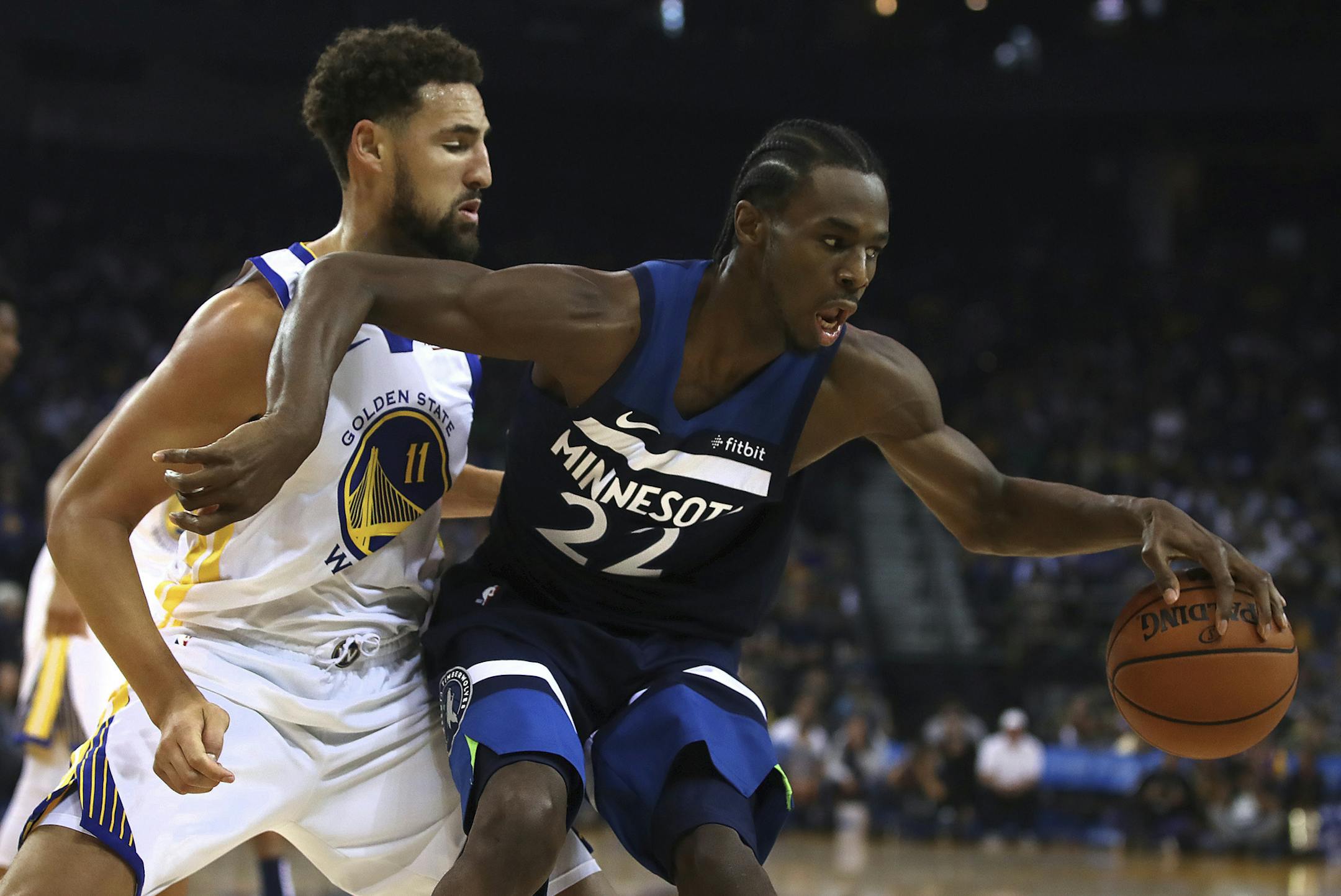 Minnesota Timberwolves' Andrew Wiggins, right, keeps the ball from Golden State Warriors' Klay Thompson (11) during the first half of an NBA preseason basketball game Saturday, Sept. 29, 2018, in Oakland, Calif. (AP Photo/Ben Margot)