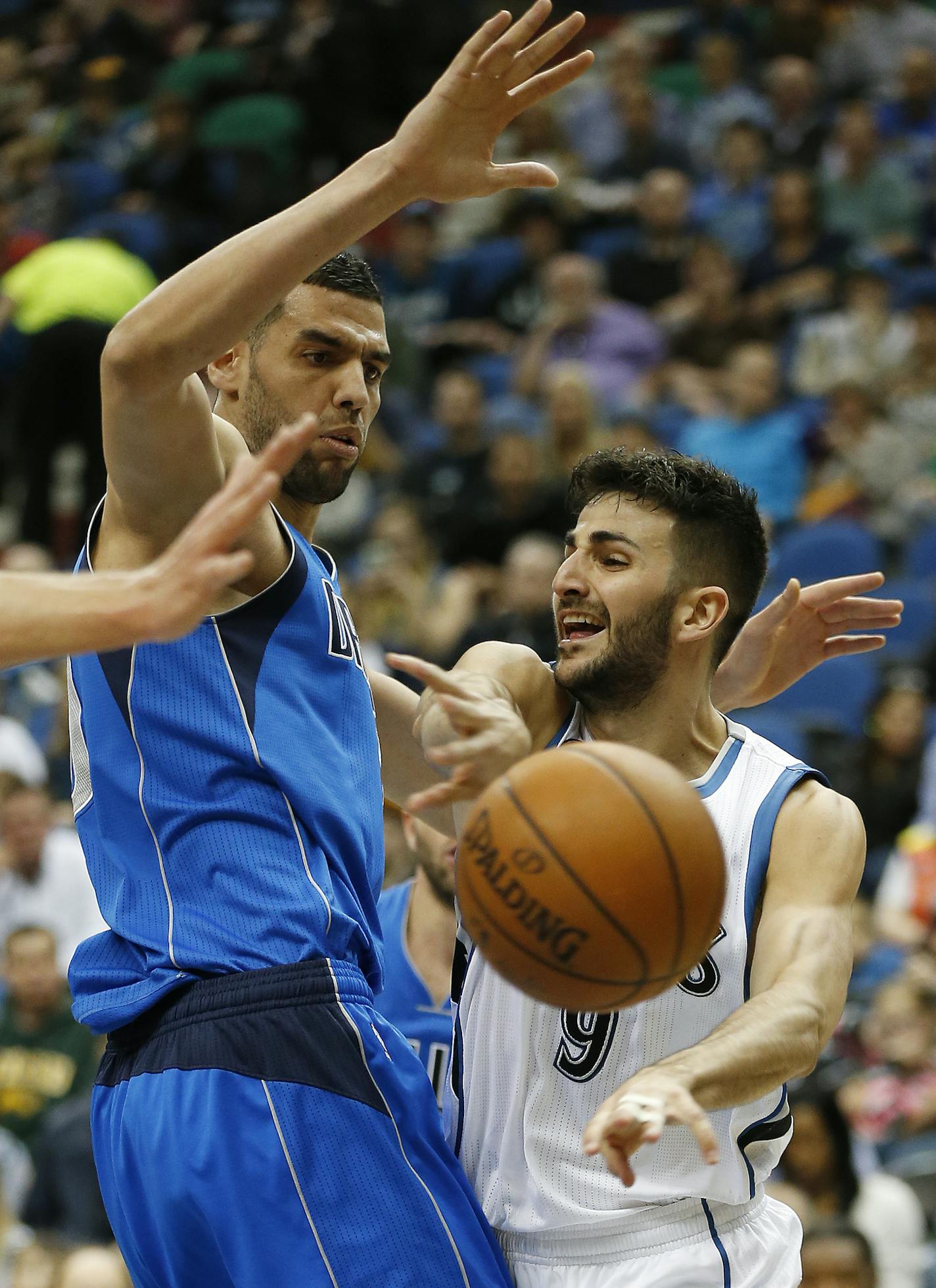 Minnesota Timberwolves guard Ricky Rubio (9) passes the ball around Dallas Mavericks center Salah Mejri (50) in the first half of an NBA basketball game Sunday, April 3, 2016, in Minneapolis. (AP Photo/Stacy Bengs)