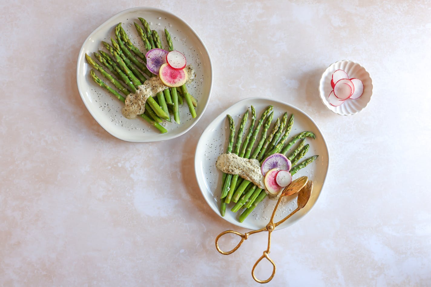 Two plates with asparagus and radishes, served with a zesty Lemon-Herb Tahini Sauce and radishes on the side.