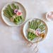 Two plates with asparagus and radishes, served with a zesty Lemon-Herb Tahini Sauce and radishes on the side.