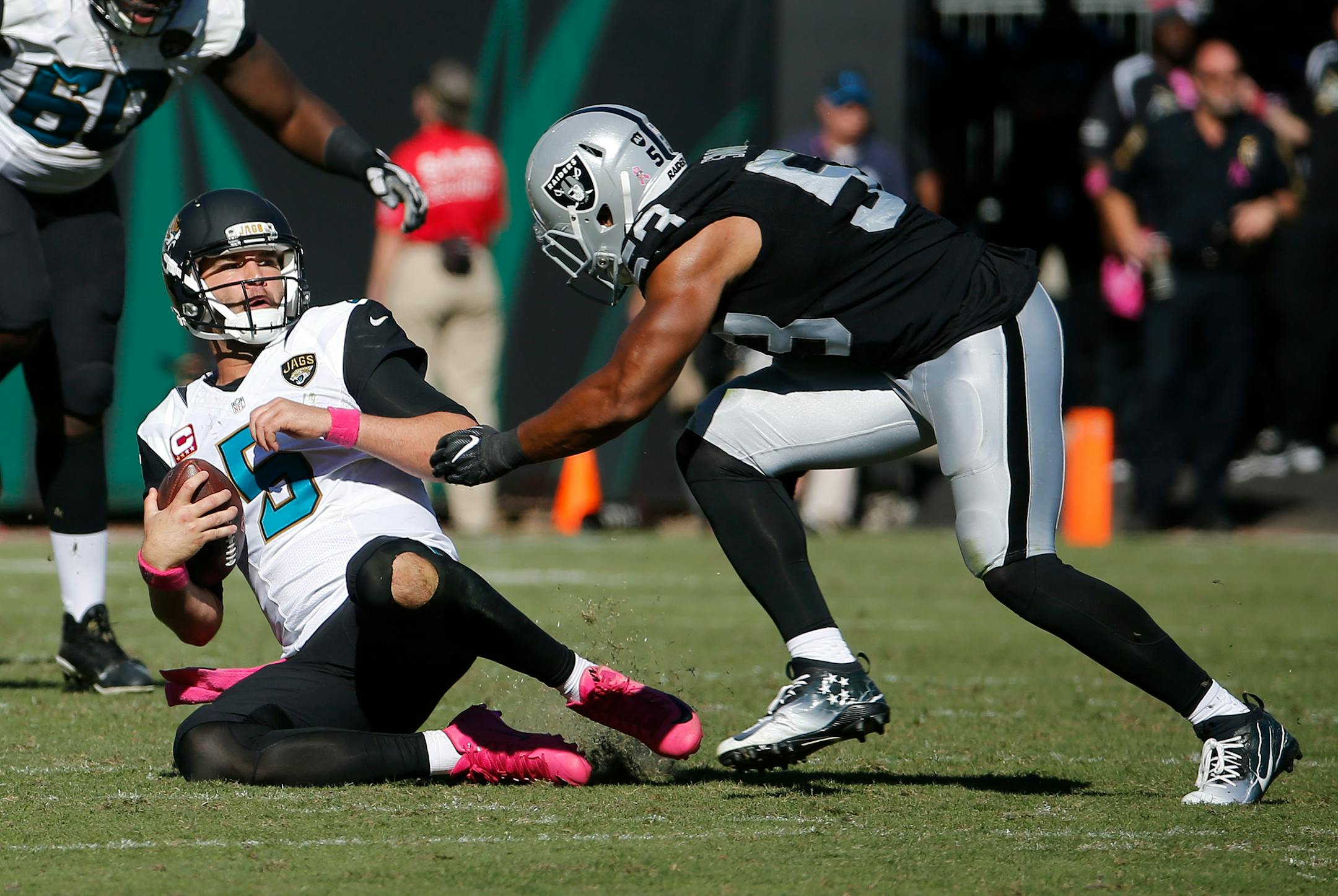 Jacksonville Jaguars quarterback Blake Bortles (5) slides in front of Oakland Raiders outside linebacker Malcolm Smith (53) during the fourth quarter of an NFL football game Sunday, Oct. 23, 2016, in Jacksonville, Fla. (AP Photo/Stephen B. Morton)