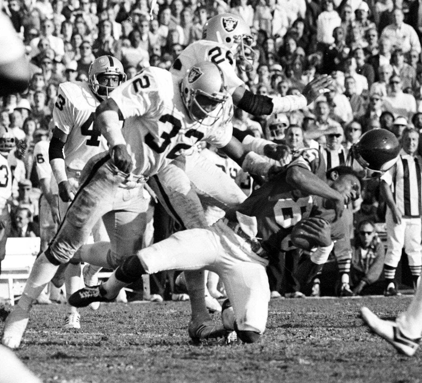 Minnesota Vikings wide receiver Sammy White loses his helmet Jan. 9,1977 as two Oakland Raiders hit him in the Super Bowl XI game at Pasadena, Calif. Raiders are, defensive backs Jack Tatum (32) and Skip Thomas. (AP Photo/Richard Drew) ORG XMIT: APHS203