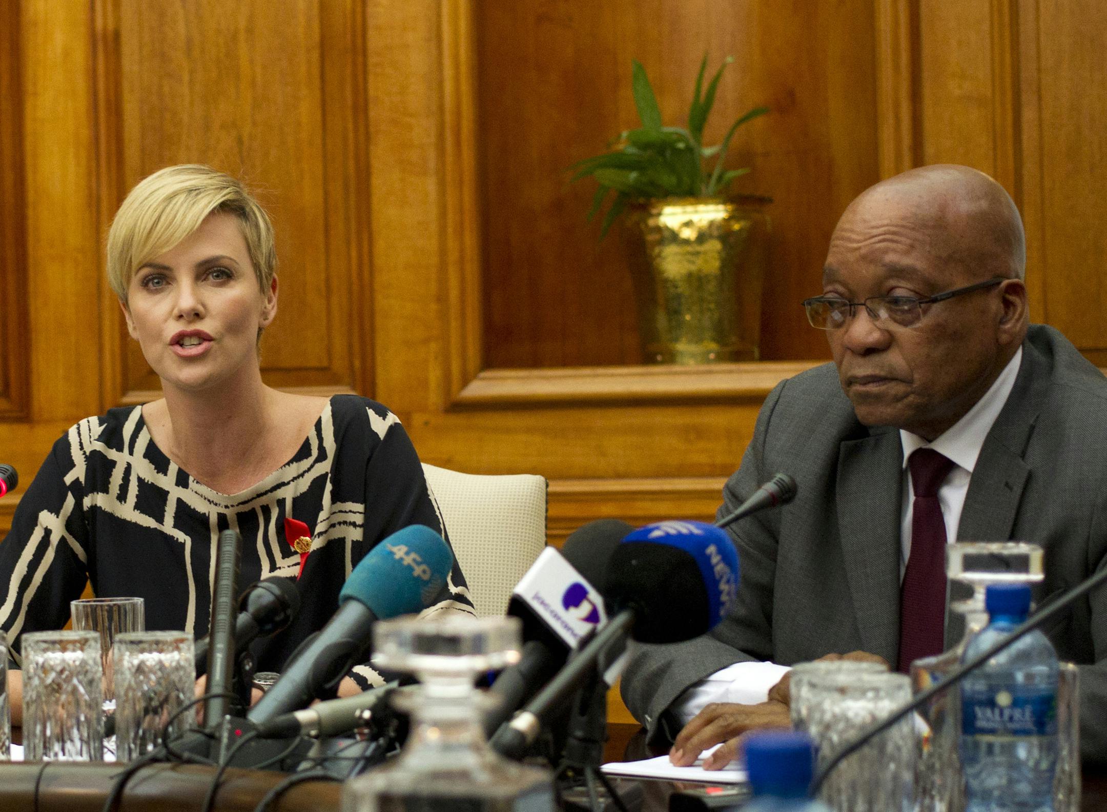 South African-born Hollywood actress Charlize Theron, left, speaks during her joint media conference with South African President Jacob Zuma, right, after their meeting at his Union Building office in Pretoria, South Africa, Monday, 29 July 2013. They discussed the fight against HIV and Aids, and "how collaboration can assist mitigate the pandemic's negative impact on young girls". (AP Photo/Themba Hadebe)