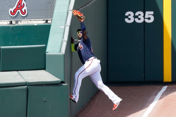 Atlanta left fielder Marcell Ozuna made a catch in foul territory to retire the Twins’ Luis Arraez on Friday in North Port, Fla.