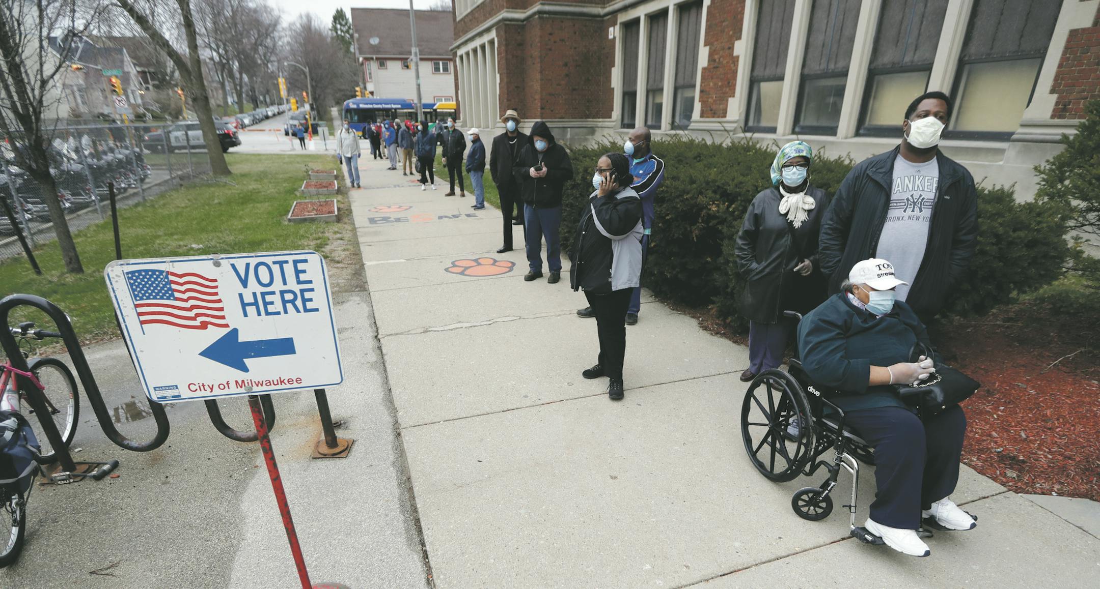 Rosie Redmon, 79, waits with her son, Deshawn Hudson, to vote in the presidential primary election while wearing masks and practicing social distancing to help slow the spread of coronavirus disease (COVID-19) at Riverside High School in Milwaukee, Wisconsin, U.S. April 7, 2020. Mike De Sisti/Milwaukee Journal Sentinel/USA TODAY NETWORK via REUTERS - RC2RZF9ZGOZ4 ORG XMIT: TOR500