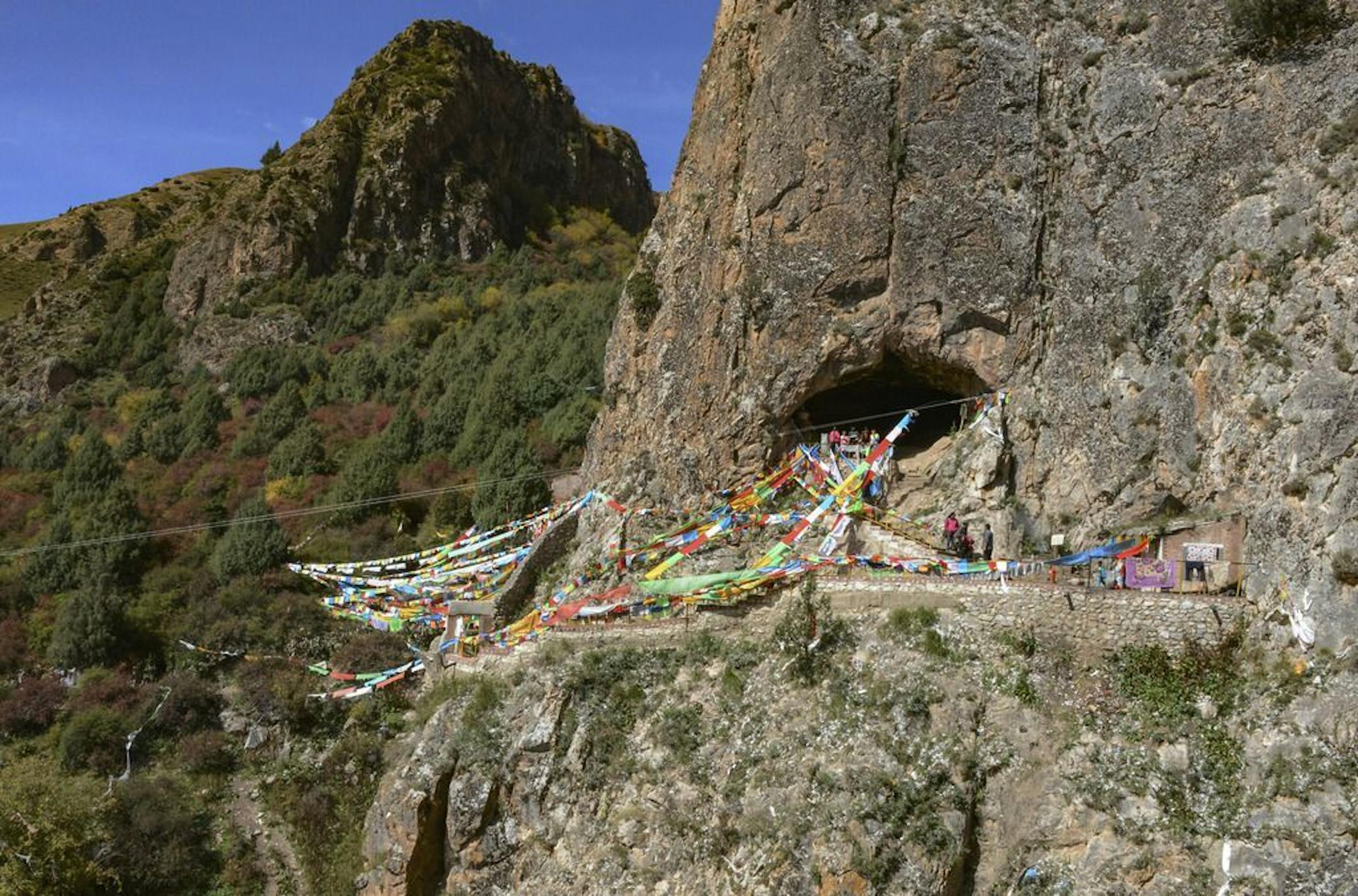 This undated photo made available by Dr. Dongju Zhang of Lanzhou University in April 2019 shows the Baishiya Karst Cave above the Jiangla riverbed in the Gansu province of China. It is both a locally famous Buddhist cave and a tourist site. According to a report released on Wednesday, May 1, 2019, a jawbone fragment found in the cave is least 160,000 years old, and recovered proteins led scientists to conclude it came from a Denisovan, a relative of Neanderthals.