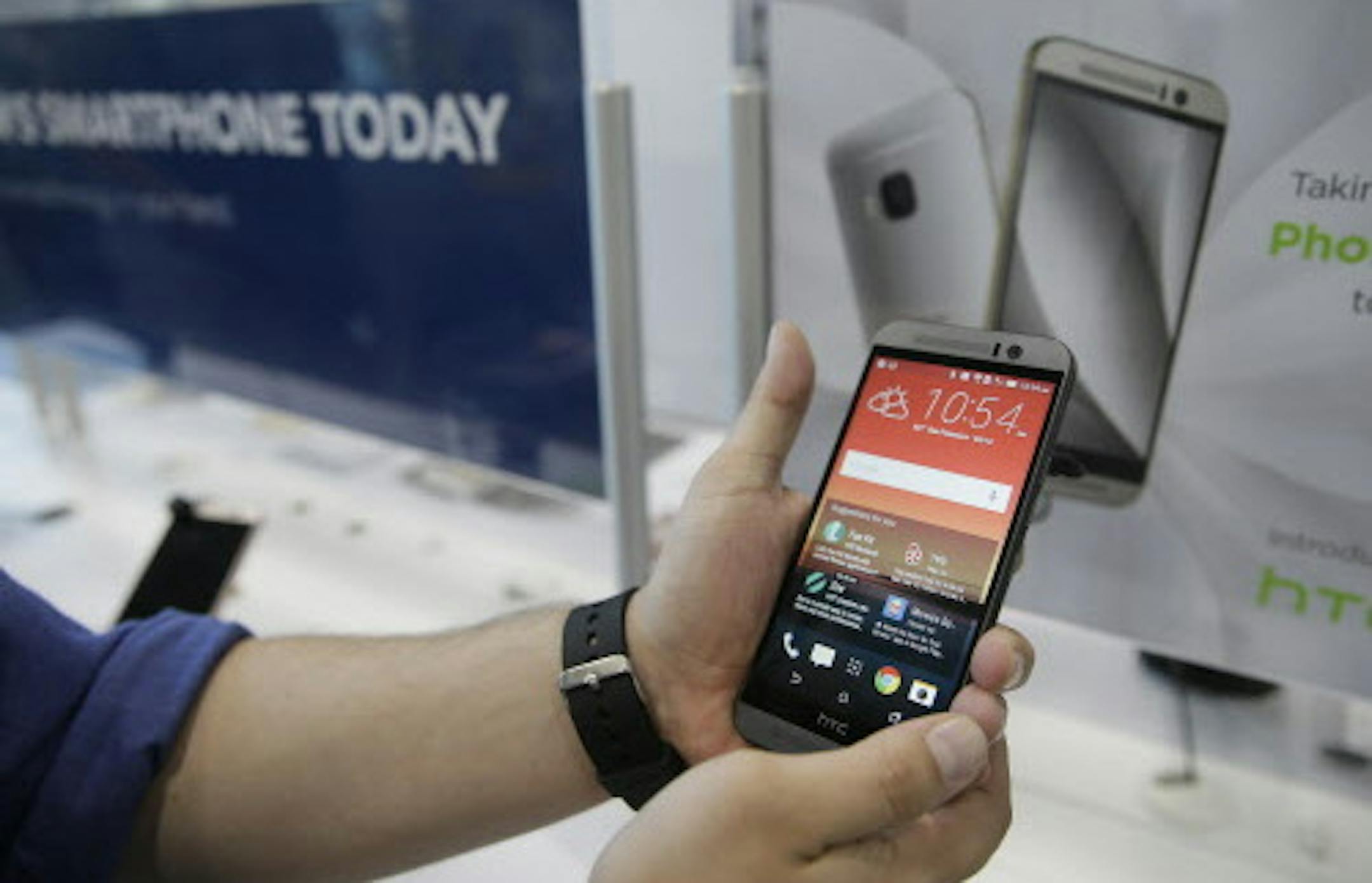 A salesperson demonstrates the new HTC One M9 smartphone that went on sale Friday, April 10, 2015, at a Best Buy store in San Francisco. HTC improved its camera and has added home-screen personalization based on location. Prices vary by carrier. No-contract versions generally start at about $650. (AP Photo/Eric Risberg)