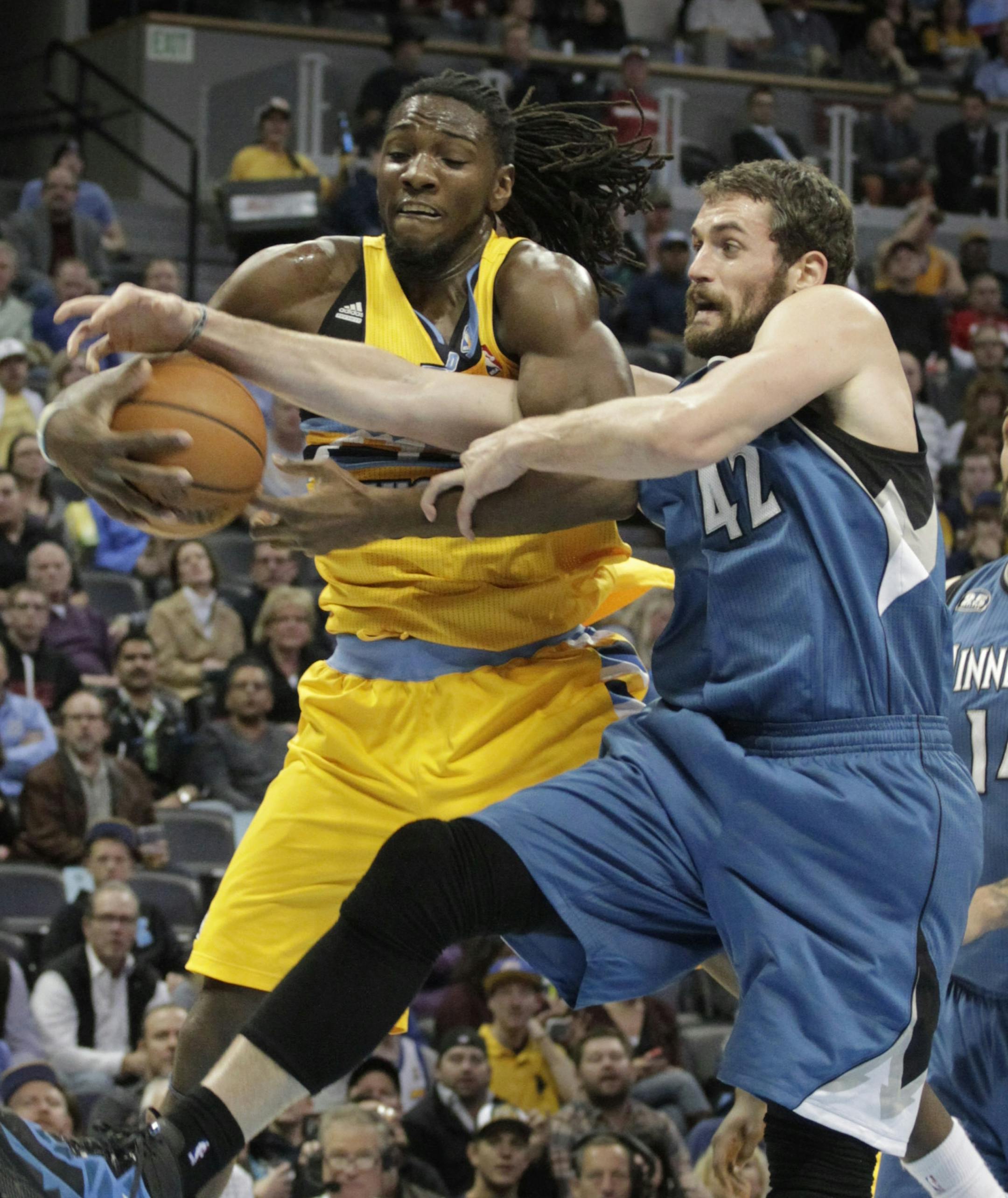 Denver Nuggets forward Kenneth Faried ,left, and Minnesota Timberwolves forward Kevin Love (42) reach for a rebound during the first quarter of an NBA basketball game in Denver, Friday, Nov. 15, 2013. (AP Photo/Joe Mahoney)