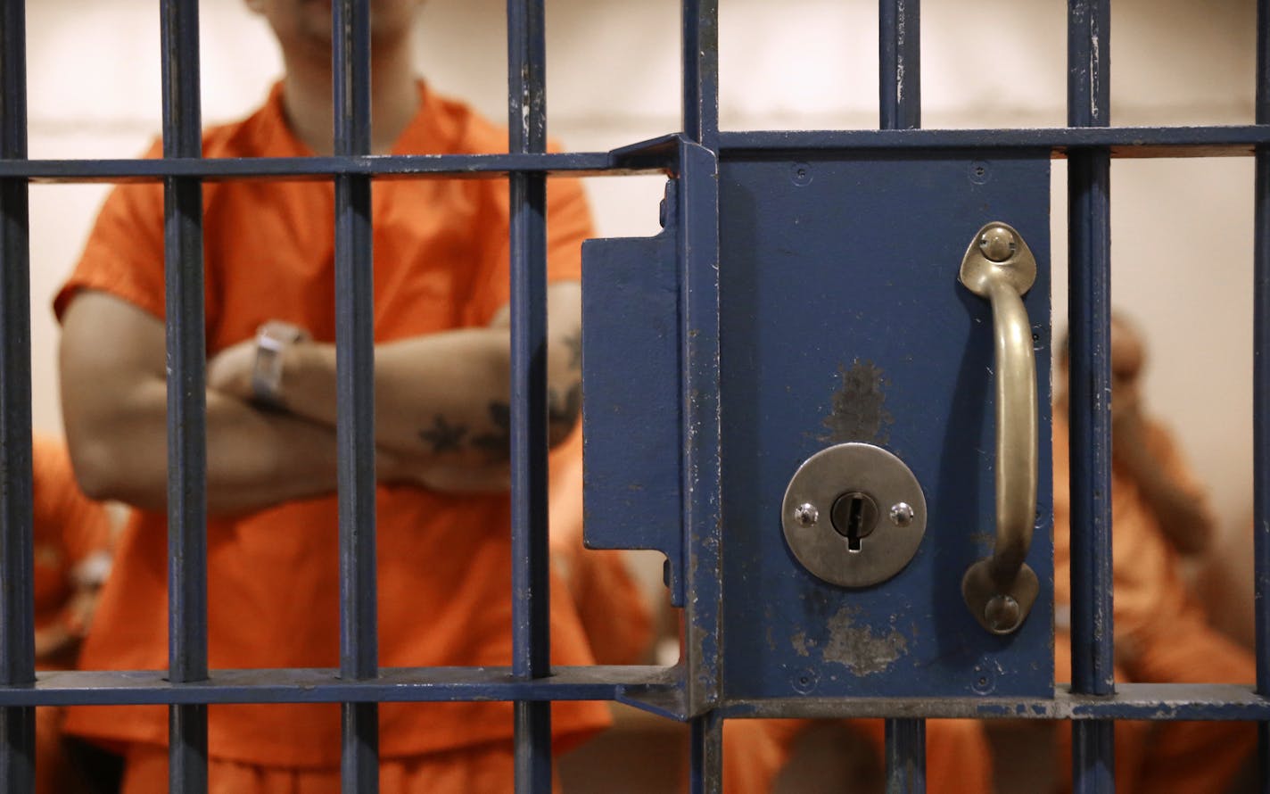 FILE - In this Nov. 1, 2016, file photo, detainees wait in a cell for an appearance in Sacramento County Superior Court in Sacramento, Calif. Gov. Gavin Newsom's proposal to sharply reduce the time a convict is under supervised release could wind up sending more criminals to jail or prison according to a report by the nonpartisan legislative analyst released Tuesday, Feb. 18, 2020. (AP Photo/Rich Pedroncelli, File)