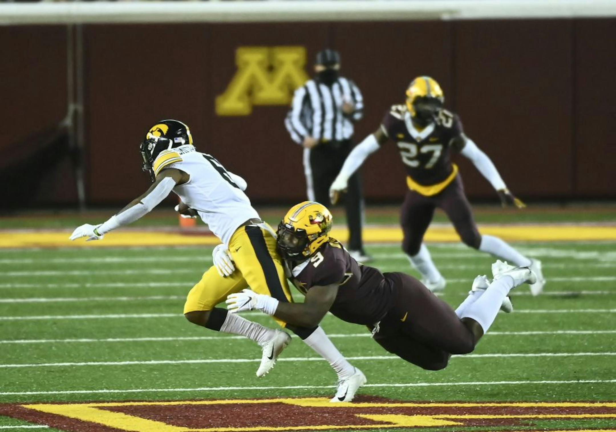 Minnesota Gophers defensive lineman Esezi Otomewo (9) tackeld Iowa Hawkeyes wide receiver Ihmir Smith-Marsette (6) for a loss of 6-yards in the second quarter.