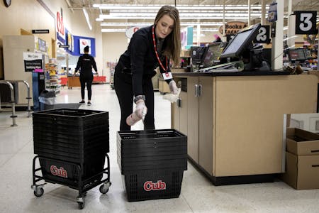 Danielle Hoppe, a customer service manager at a Cub Food in Mankato cleaned grocery baskets. Hoppe is full-time student paying for school with her job