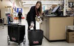 Danielle Hoppe, a customer service manager at a Cub Food in Mankato cleaned grocery baskets. Hoppe is full-time student paying for school with her job