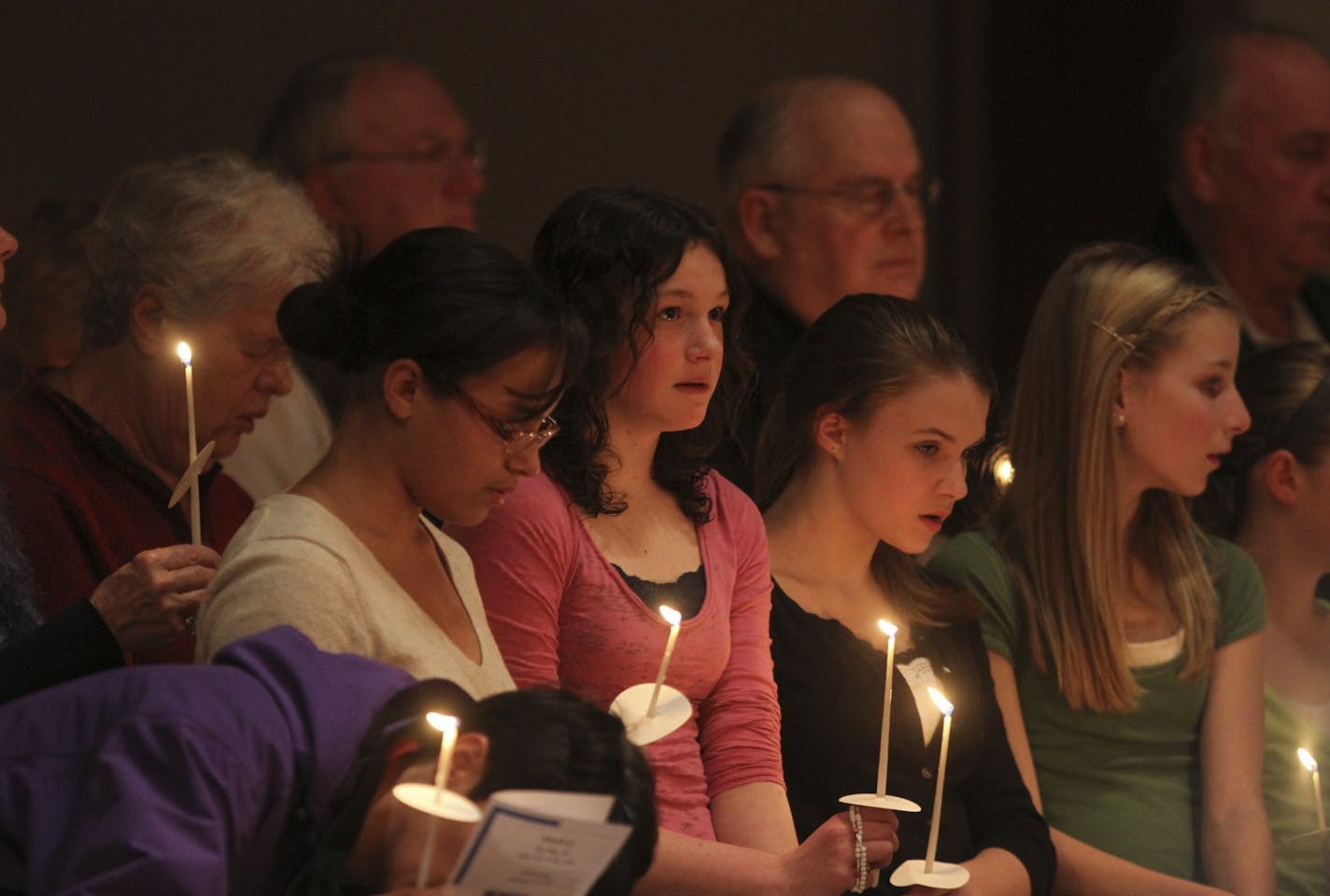 Lexi Heil, in pink, stood with friends and family during a prayer vigil Wednesday for her grandparents Jerry and Barbara Heil at the Church of St. Pius X in White Bear Lake. They have been missing since the ship capsized in the Mediterranean. "Your prayers have made a big difference," Lexi Heil told the congregation.