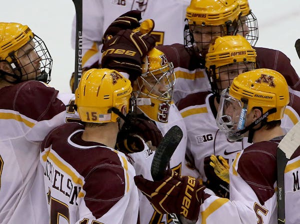Gophers' goalie Adam Wilcox celebrates with teammates after a win against Notre Dame