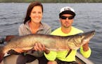 Stacie Hassing of Easton, Minn., with a 45.5-inch muskie she caught and released on Leech Lake. Helping her hold the fish is her brother, Nathan Stind