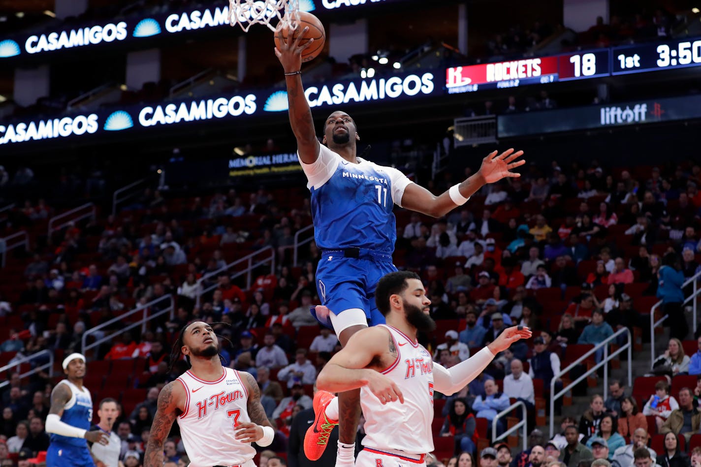 Timberwolves center Naz Reid flushed a layup over Houston forward Cam Whitmore (7) and guard Fred VanVleet, right, during the first half Friday