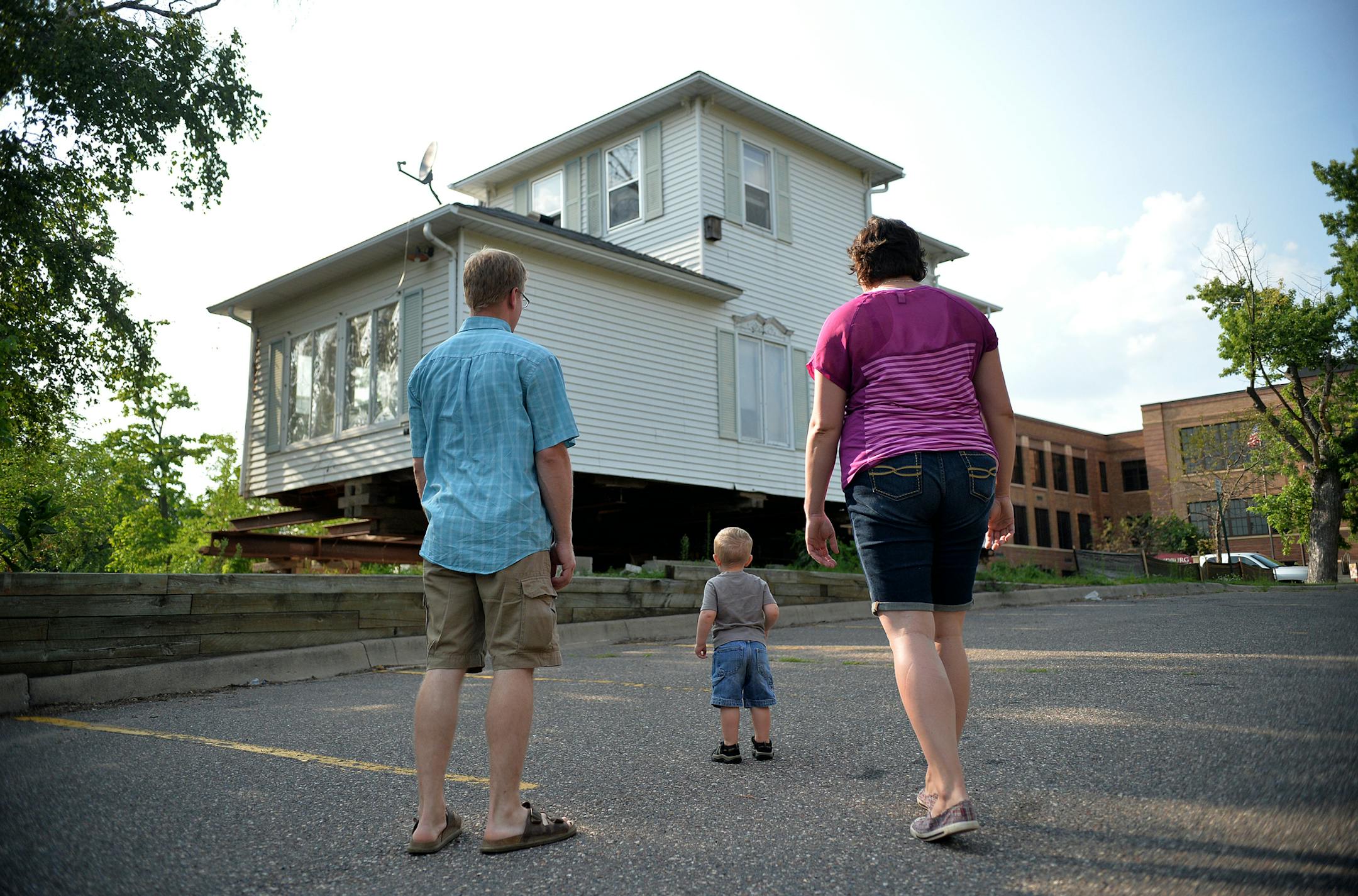 Amanda and Erik Skogquist and their son, Everett, 2, look over the exterior of their newly purchased historic home's current location. ] (SPECIAL TO THE STAR TRIBUNE/BRE McGEE) **Amanda Skogquist (right), Erik Skogquist (left), Everett Skogquist (center, 2)