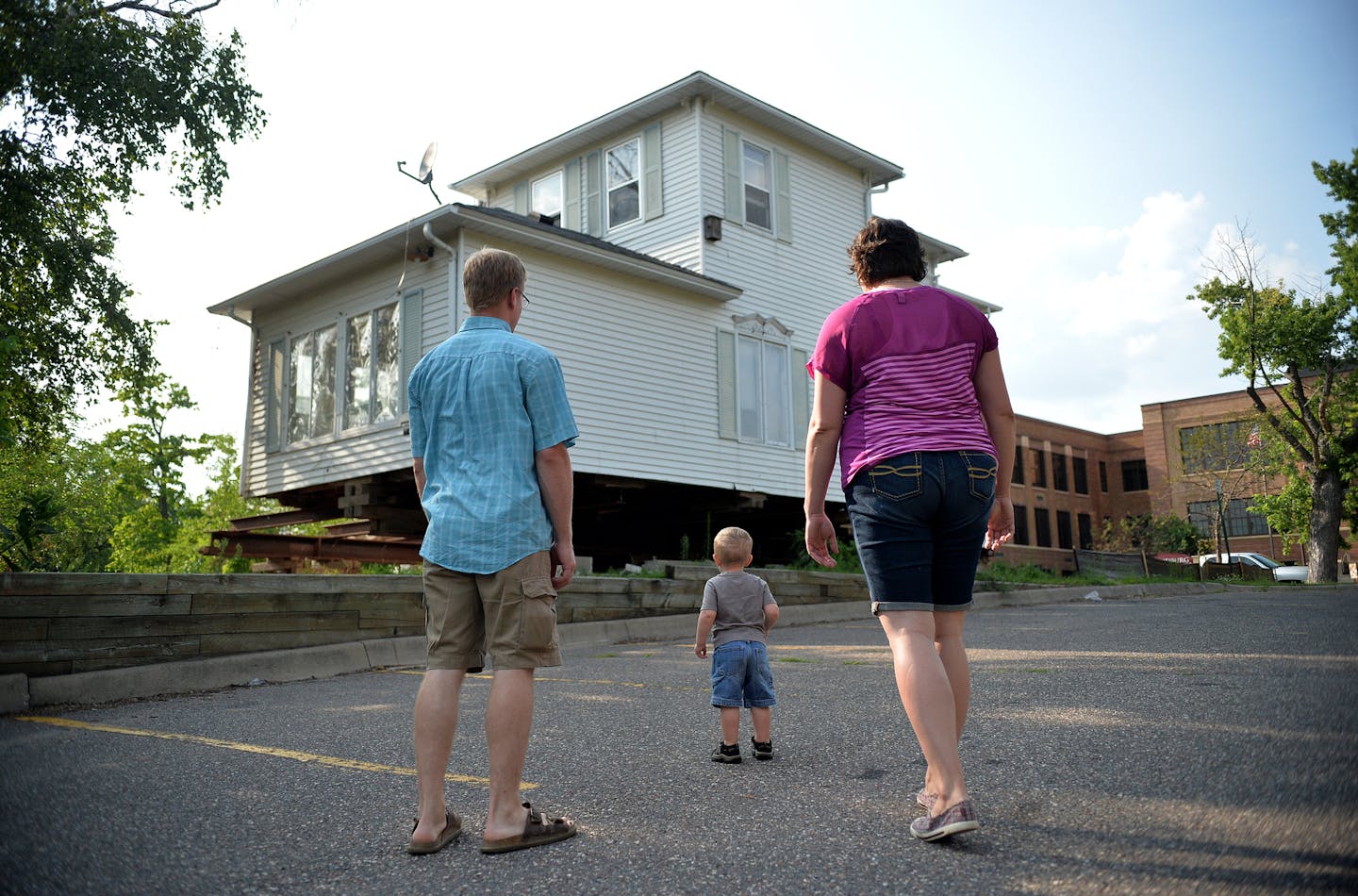 Amanda and Erik Skogquist and their son, Everett, 2, look over the exterior of their newly purchased historic home's current location. ] (SPECIAL TO THE STAR TRIBUNE/BRE McGEE) **Amanda Skogquist (right), Erik Skogquist (left), Everett Skogquist (center, 2)