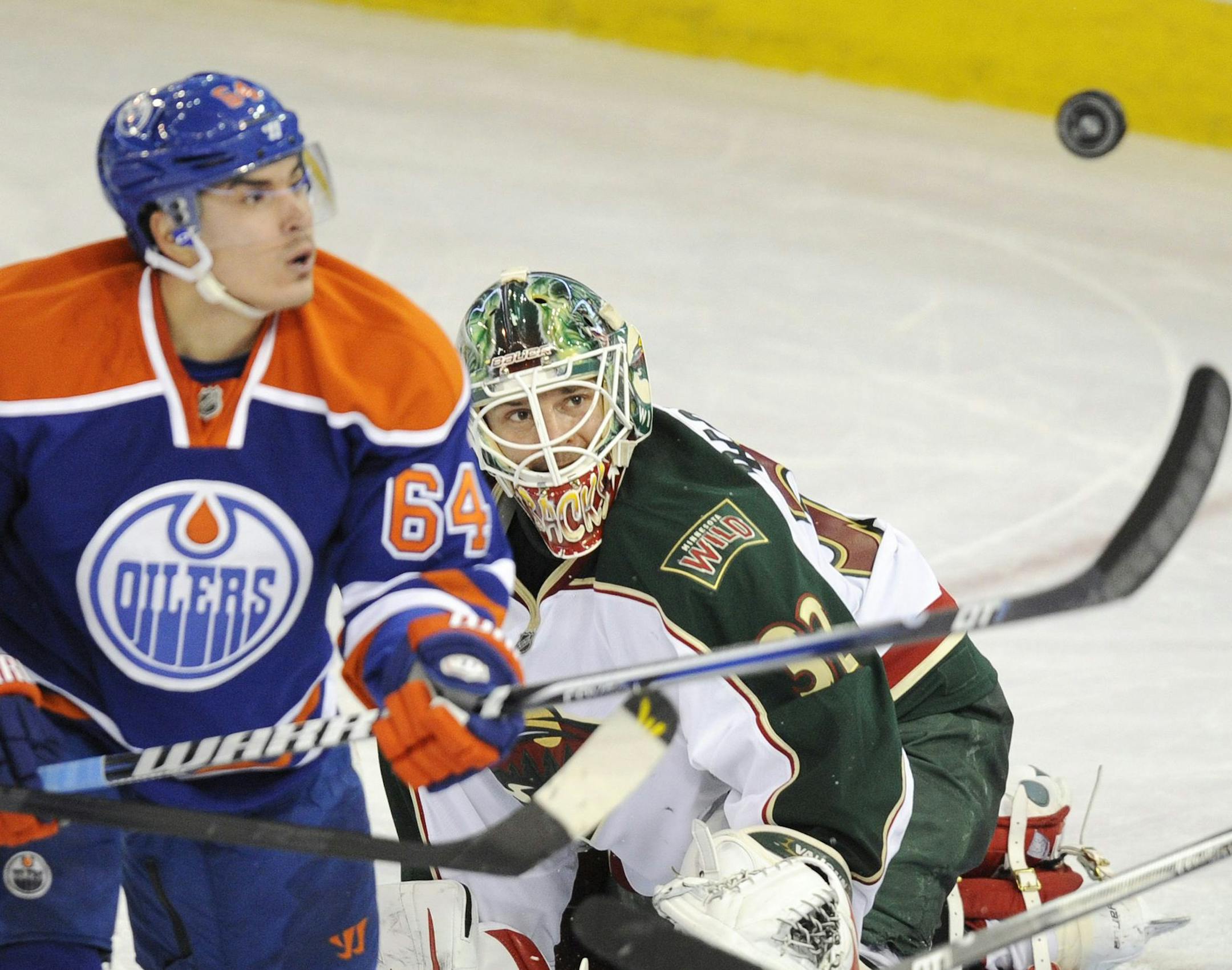 Minnesota Wild goalie Niklas Backstrom watches as the Edmonton Oilers' Nail Yakupov, left, tries to knock the puck out of the air during second period NHL hockey action in Edmonton, Alberta, on Tuesday, April 16, 2013. (AP Photo/The Canadian Press, John Ulan)