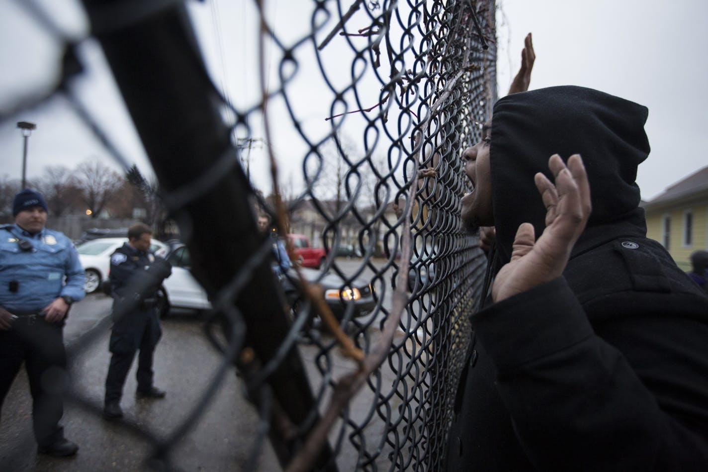 Members of Black Lives Matter and community protesters yelled through a gate at the back entrance of the Minneapolis Police Department's fourth precinct headquarters in north Minneapolis in the wake of police shooting and critically wounding a man over the weekend. Photographed on Monday, November 16, 2015, in Minneapolis, Minn.