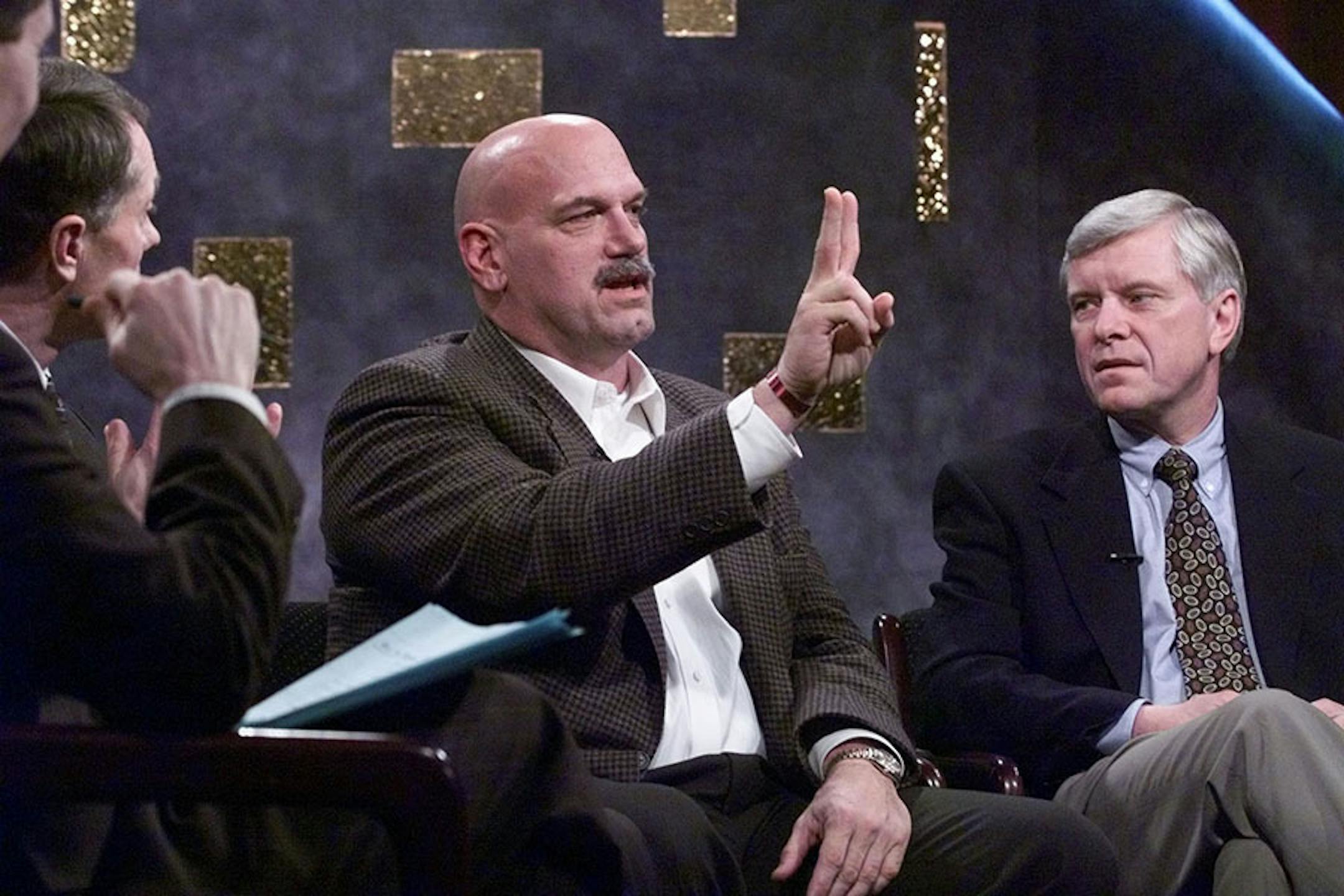 House Speaker Steven Sviggum, Governor Jesse Ventura, and Senate Majority Leader Roger Moe listened to a pre-selected panel of citizens on how state government should use or give back the tax surplus. Here Ventura advocates a bi-annual state budget (hence two fingers). This town meeting linked citizens by video from Mankato, Bemidji and Minneapolis. -- This pic in studio of KTCA, channel 2, in downtown St. Paul.