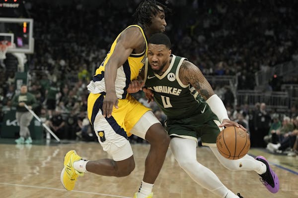 The Bucks' Damian Lillard gets past the Pacers' Aaron Nesmith during the first half Sunday in Milwaukee.