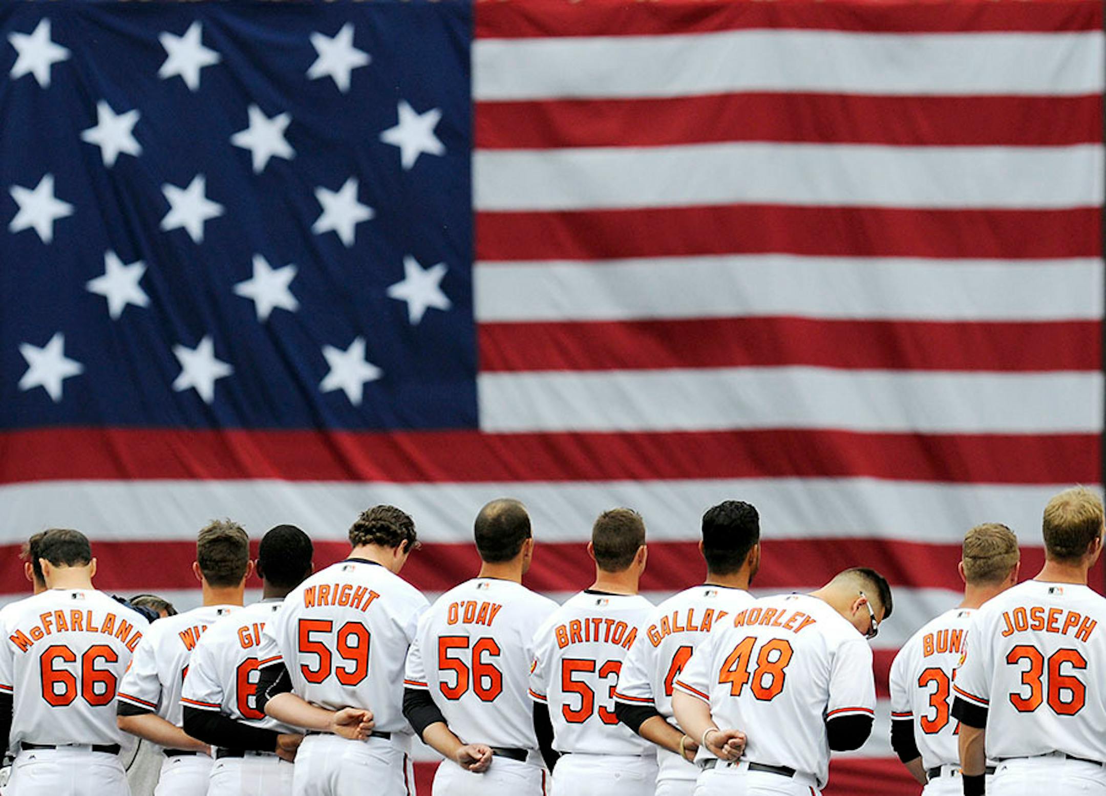 Players stand for the National Anthem before the Baltimore Orioles' opener against the Minnesota Twins on Monday, April 4, 2016, at Oriole Park at Camden Yards in Baltimore. (Dylan Slagle/Baltimore Sun/TNS) ORG XMIT: 1182892