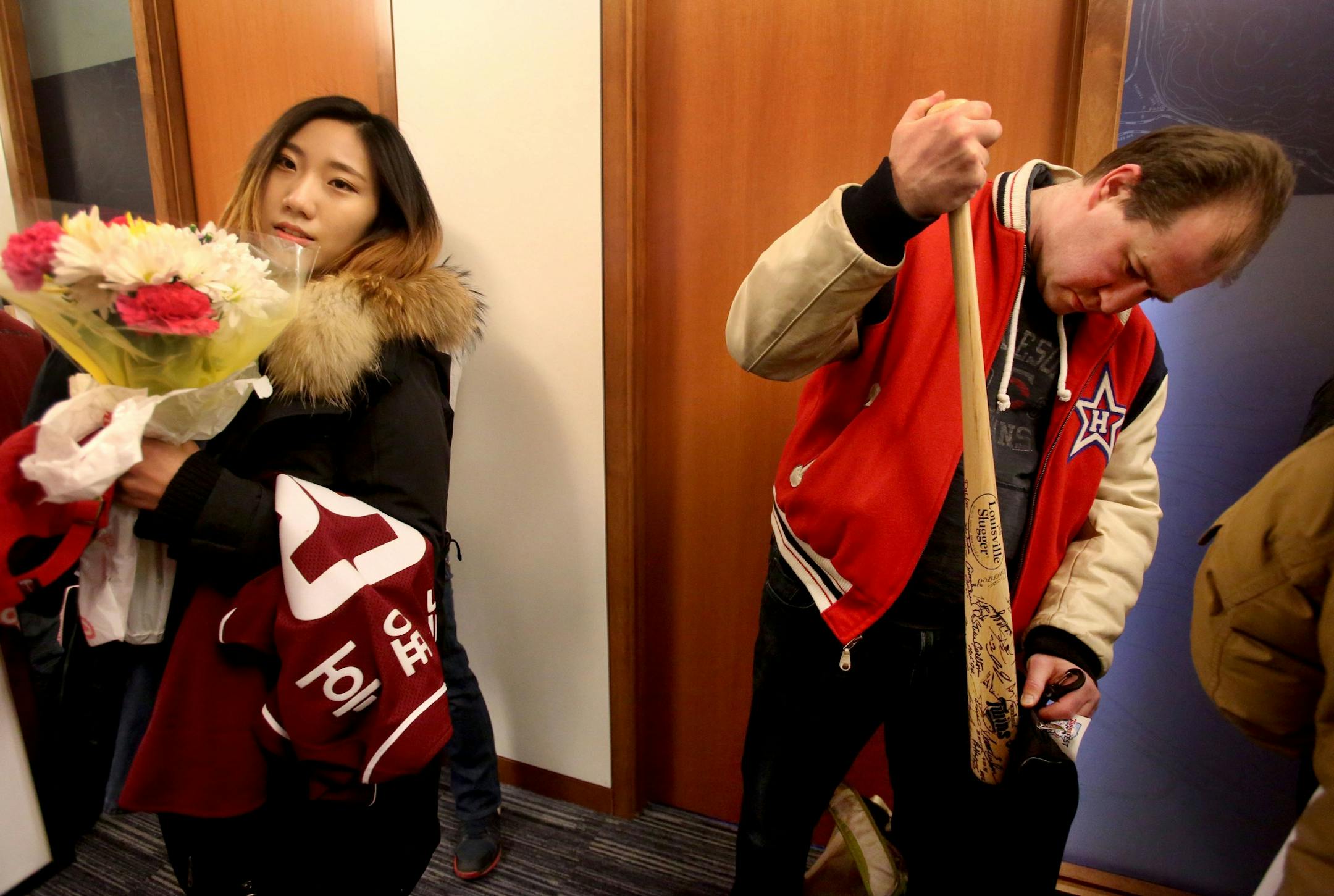 Adella Yoon, left, traveled from Ann Arbor, MI, to bring a bouquet of flowers for hero and new Twins slugger Byung Ho Park from South Korea while Justin Schroeder of Plymouth searched on his Twins autograph bat for a fresh signature from young Twin Miguel Sano during Twinsfest, Friday, Jan. 29, 2016, at Target Field in Minneapolis, MN.