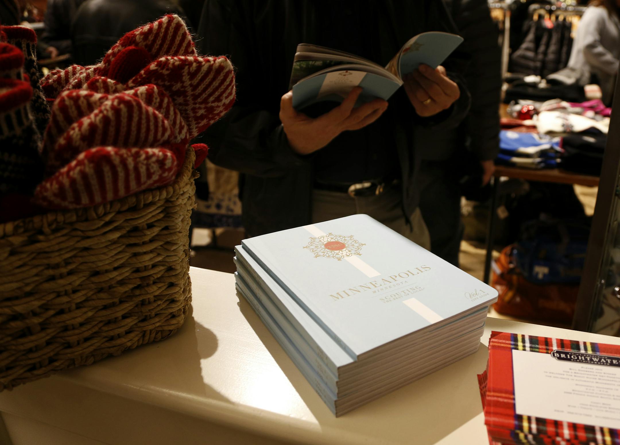 An attendee looked through a Scout Guide during a launch party for the magazine at Brightwater in Edina. ] CARLOS GONZALEZ cgonzalez@startribune.com - November 12, 2014, Edina, Minn., Bill Damberg, owner of Brightwater, is holding a launch party for the Scout Guide in his retail store featured in the mag.