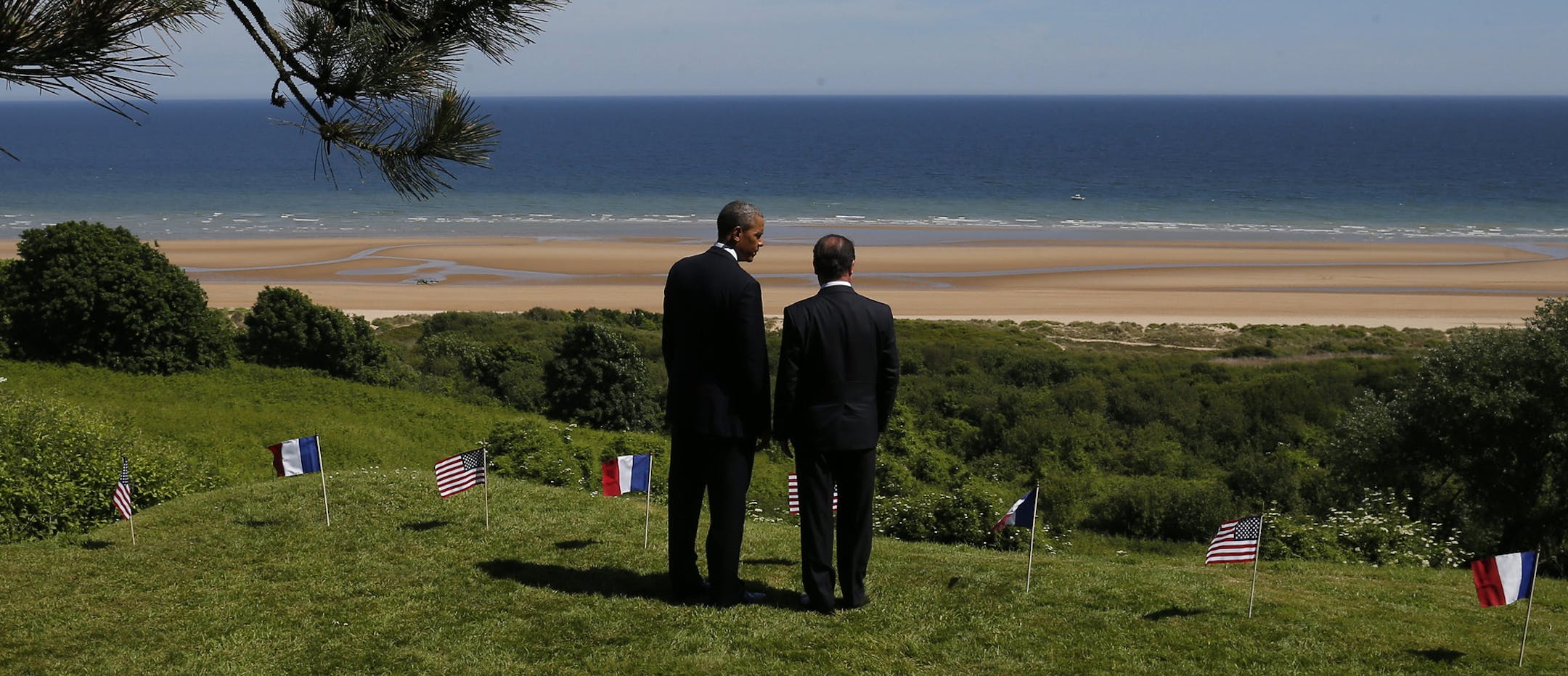 U.S. President Barack Obama and French President Francois Hollande look out at Omaha Beach, one of the sites of the Allied soldiers beach landings, at Normandy American Cemetery as they participate in the 70th anniversary of D-Day in Colleville sur Mer in Normandy, France, Friday, June 6, 2014. (AP Photo/Charles Dharapak)