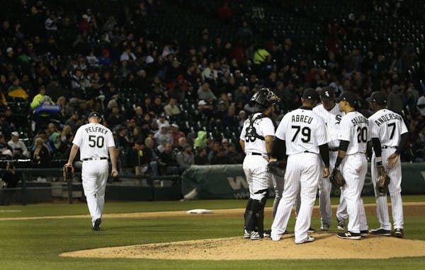 Chicago White Sox starting pitcher Mike Pelfrey, left, heads to the dugout after being taken out of the baseball game by manager Rick Renteria, during