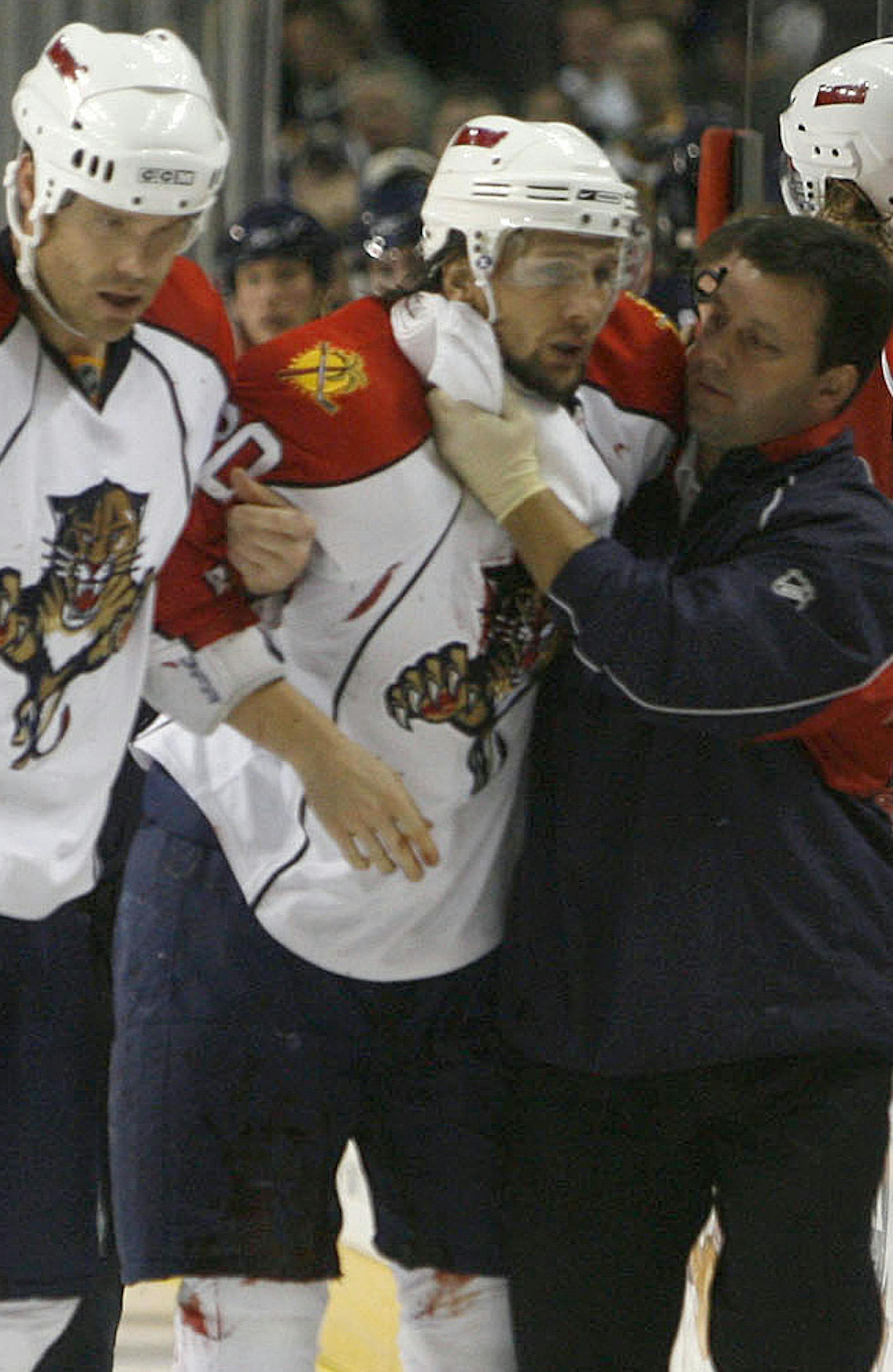 Florida Panthers' Richard Zednik (20) is assisted by teammate Jassen Cullimore (22) and an unidentified trainer, right, after he was hurt during their NHL hockey game against the Buffalo Sabres in Buffalo, N.Y., Sunday Feb. 10, 2008. Blood gushed from Zednick's neck after being struck by a teammates skate creating a frightening moment that delayed the game for about 15 minutes. Two hours after the game, the Panthers announced Zednik was resting comfortably at Buffalo General Hospital after havin