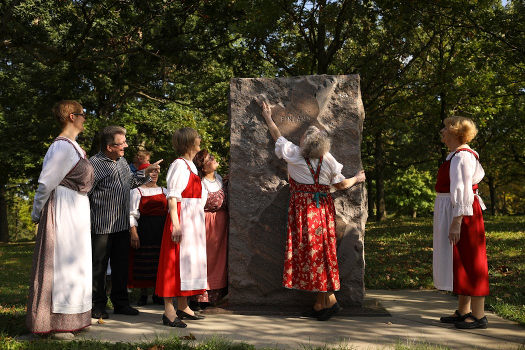 A member of a Finland-based theater group points to a map of Finland on a monument in Minneapolis' Theodore Wirth Park in 2017. The gathering was part of FinnFest, an annual event honoring Finnish culture.