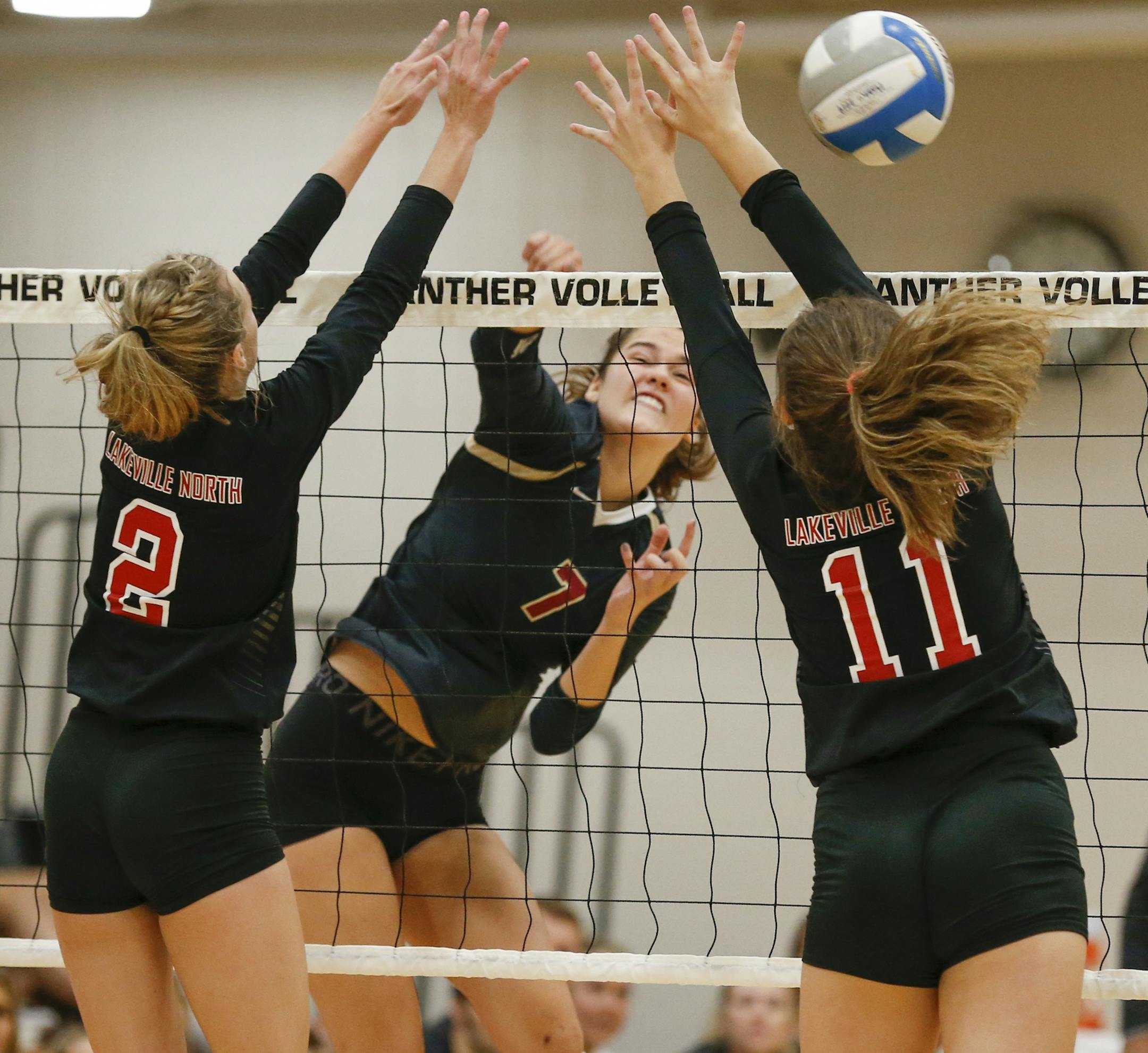 Lakeville South's Ava Moes goes up for a kill as Lakeville North's Maddy Hornyak and Abbey Milner defend. Despite Moes's 22 kills, the Cougars fell to the Panthers in four sets on Sept. 12, 2019. Photo by Jeff Lawler, SportsEngine