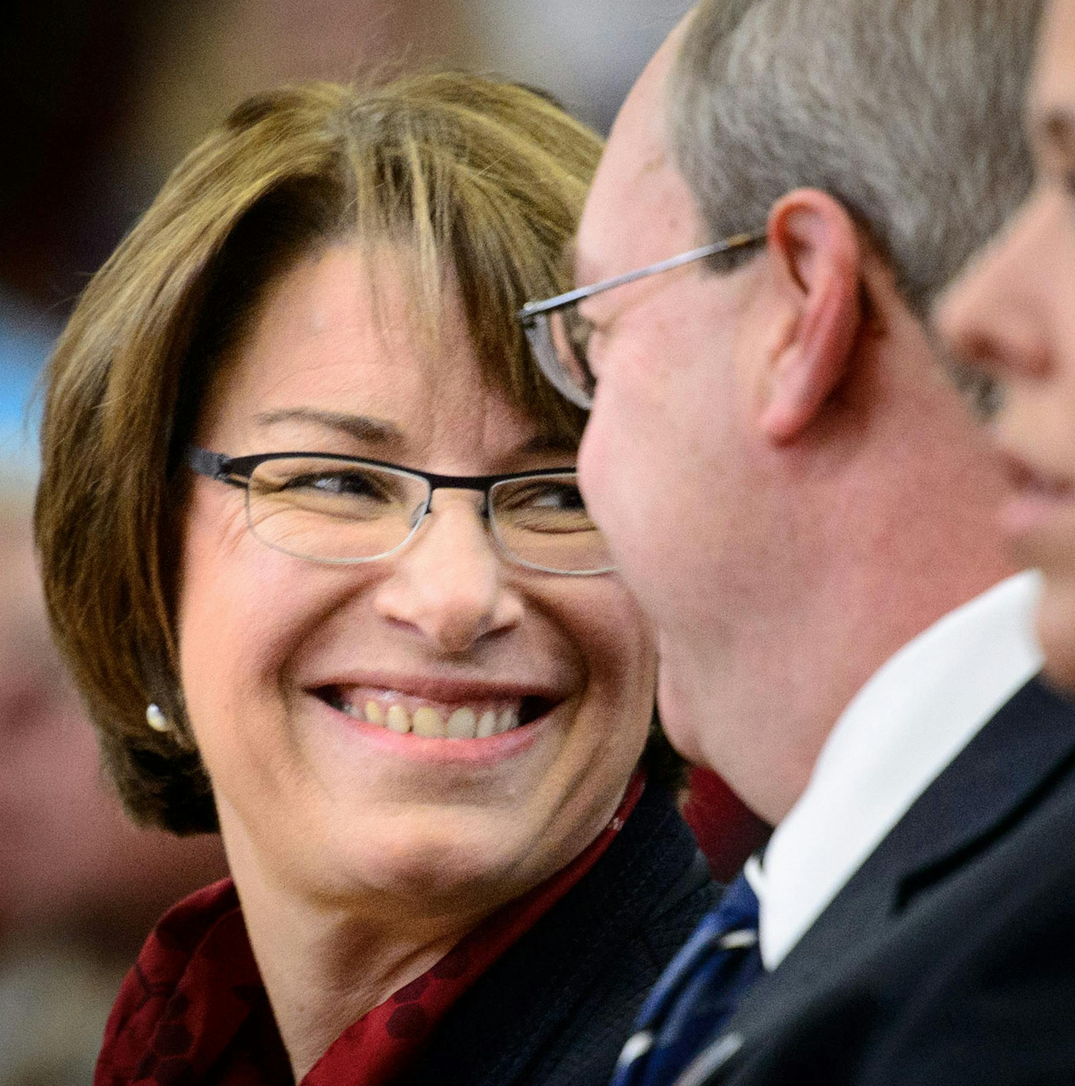 Senator Amy Klobuchar smiled at a veteran seated behind her at Hastings High School. ] GLEN STUBBE * gstubbe@startribune.com Tuesday, November 11, 2014 Hastings High School Veterans Day celebration.