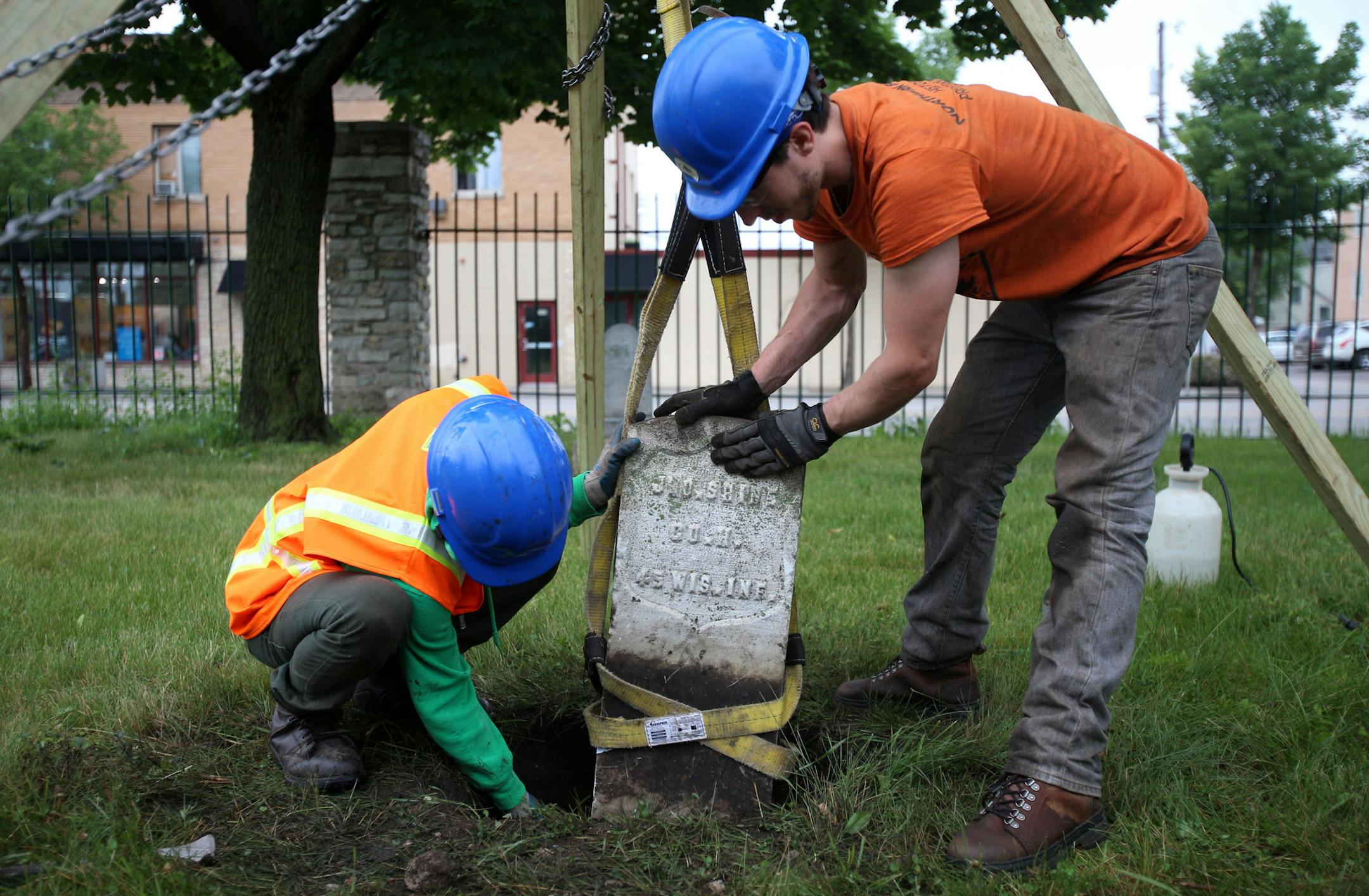 Mahoo Ya (left) attempted to lay down some support st the foundation a tombstone while Addison Galagan held the tombstone in place on Monday. ] ALEX KORMANN &#x2022; alex.kormann@startribune.com A small group of Northern Bedrock Historic Preservation Corps members worked on a "hitch" or eight day stretch of service at Pioneers & Soldiers Memorial Cemetery in Minneapolis on Monday. The crew worked to clean headstones, repair foundation and hedge around the grave markers. "Minnesota has a lot of p