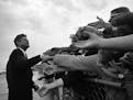 President John F. Kennedy signed legislation creating the Peace Corps 60 years ago, on Sept. 22. Above, he is greeted by supporters as he arrives to i