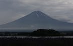 In this Wednesday, July 3, 2013 photo, Mount Fuji is seen in early morning in Kawaguchiko town, Yamanashi prefecture, Japan. Japan's most iconic landm