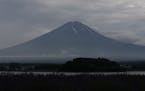 In this Wednesday, July 3, 2013 photo, Mount Fuji is seen in early morning in Kawaguchiko town, Yamanashi prefecture, Japan. Japan's most iconic landm