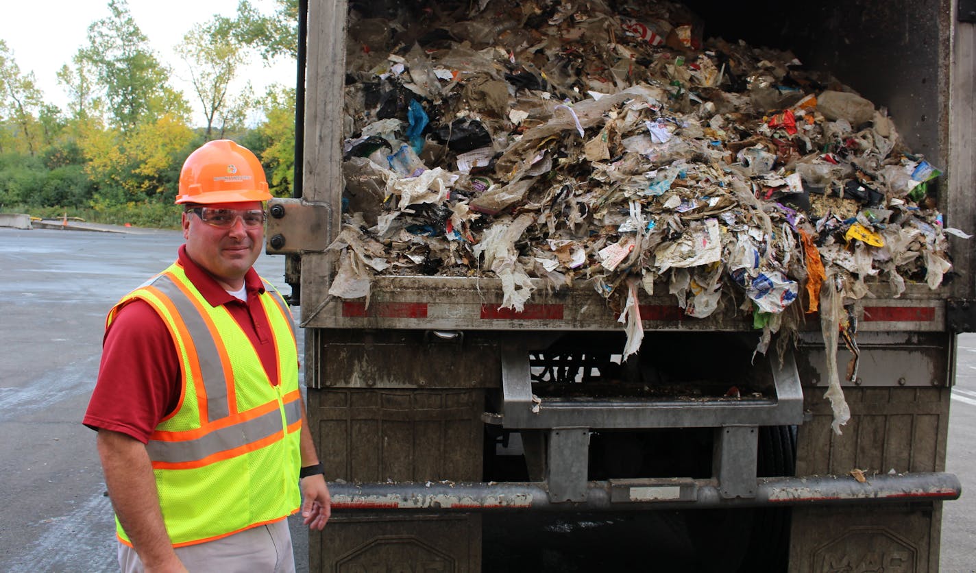 Ramsey/Washington Recycling & Energy Center Facility Manager Ryan Tritz stands in front of a truck loaded with refused-derived fuel, the final product that's shipped to Xcel Energy plants to be incinerated.