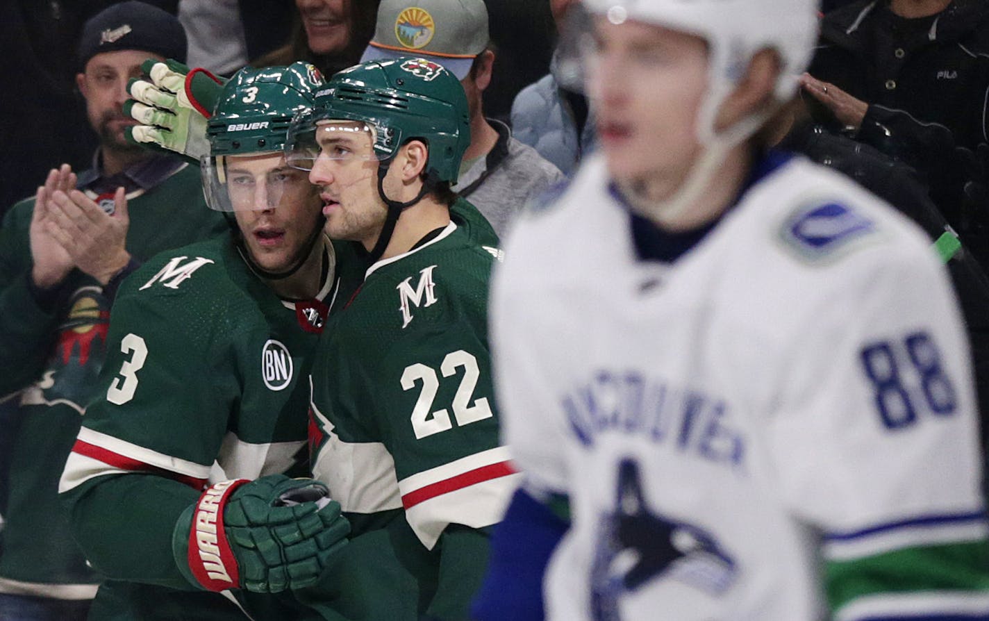 Minnesota Wild player Charlie Coyle (3) and Nino Niederreiter (22) celebrate Coyle's goal while Vancouver Canucks center Adam Gaudette skates past during the first period of an NHL hockey game Thursday, Nov. 15, 2018, in St. Paul, Minn. The Wild defeated the Canucks 6-2. (AP Photo/Andy Clayton-King)