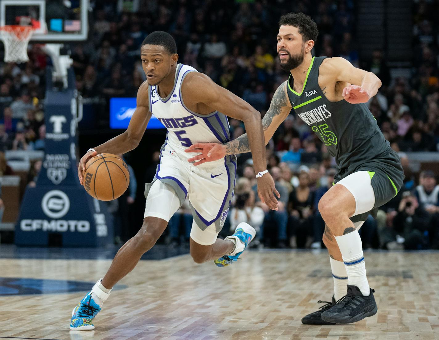 Sacramento Kings guard De'Aaron Fox (5) dribbles past Minnesota Timberwolves guard Austin Rivers (25) in the third quarter Saturday, Jan. 28, 2023 at Target Center in Minneapolis. ]